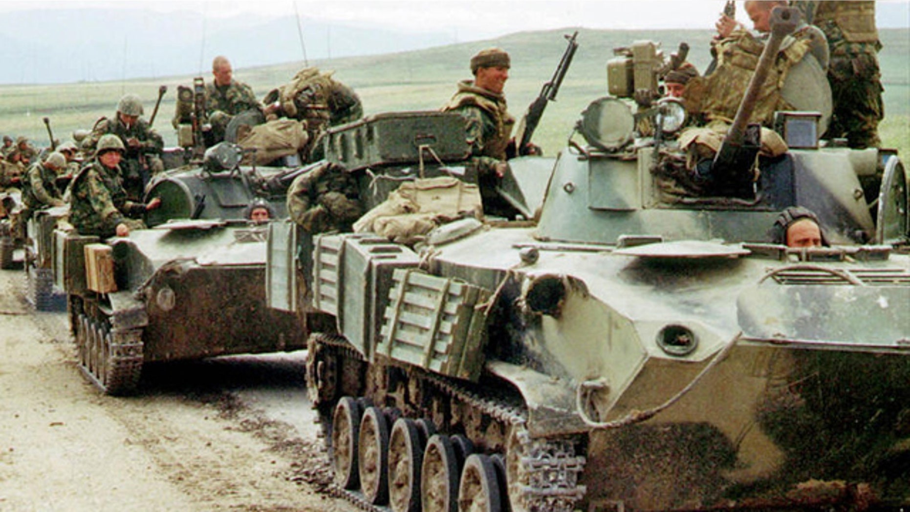 File: Russian paratroopers atop armored personnel carriers.