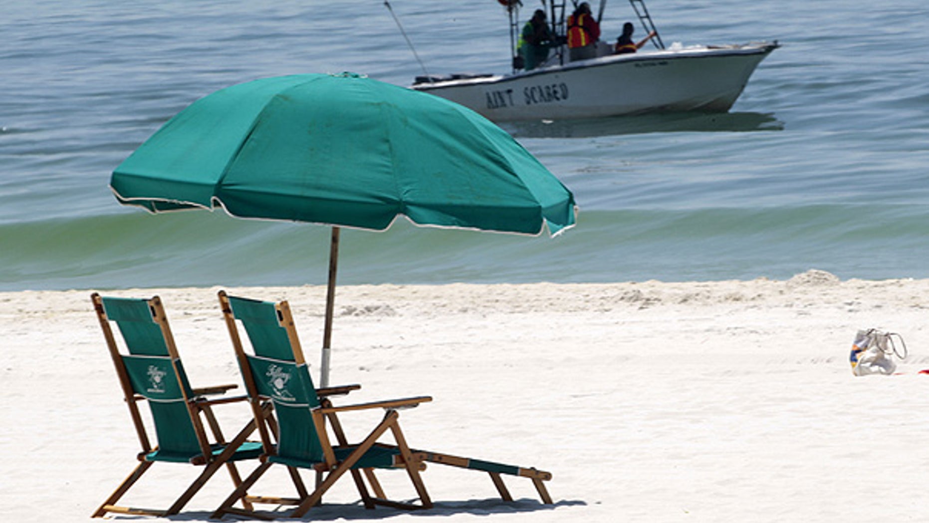 June 25: A boat skims for oil just off the beach in Pensacola Beach, Fla.