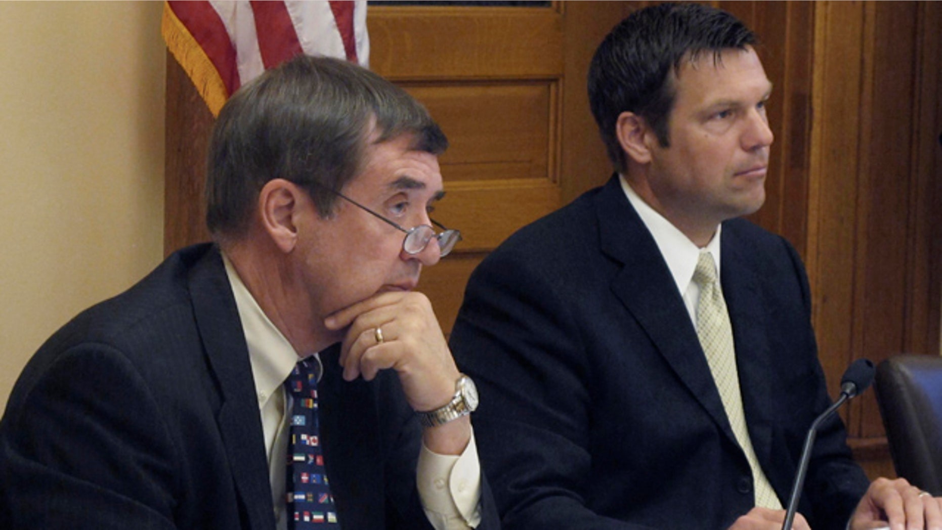 June 30: Kansas Secretary of Administration Dennis Taylor, left, and Secretary of State Kris Kobach, right, listen to a presentation on new regulations for abortion clinics at the Statehouse in Topeka, Kan.