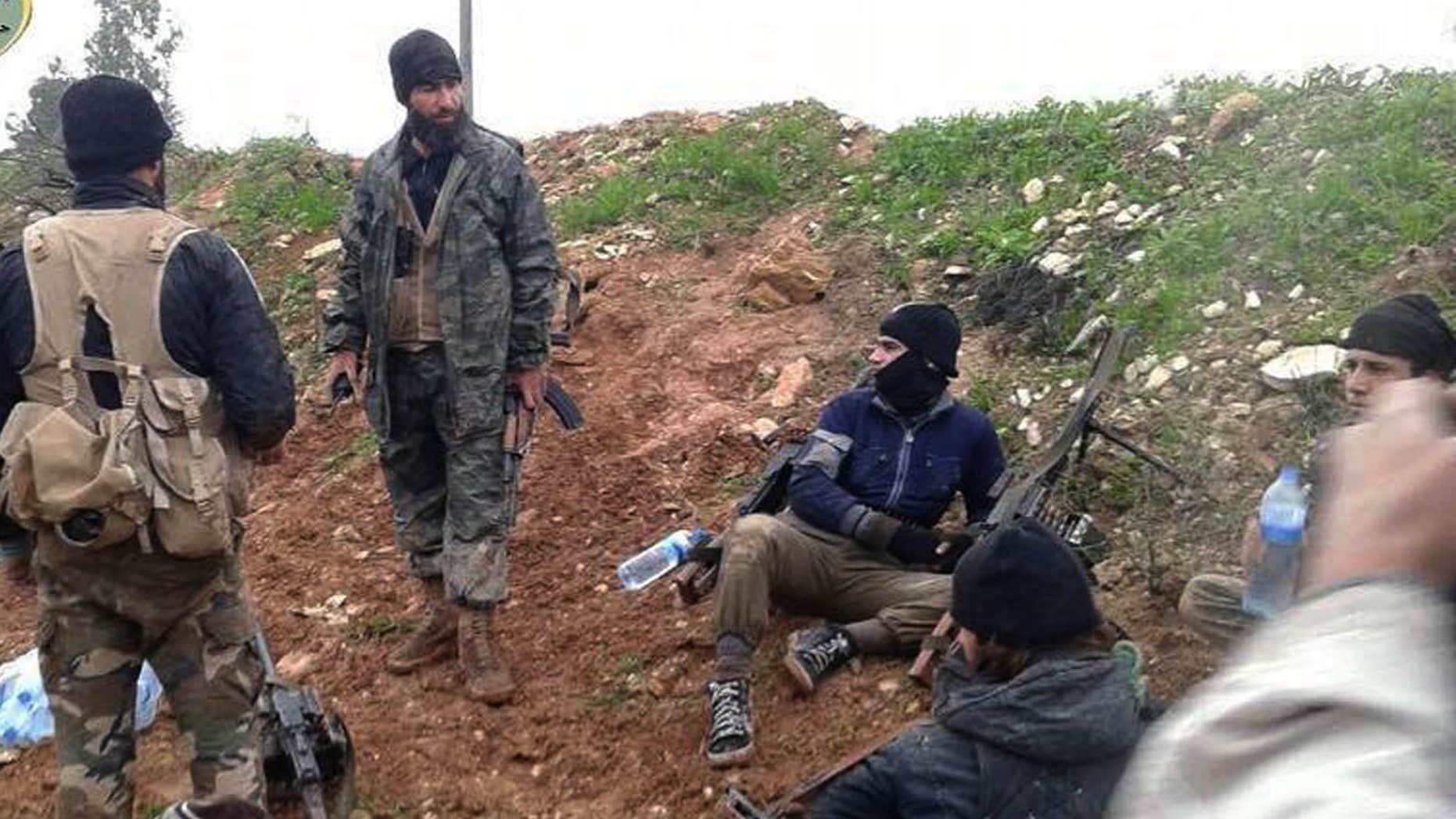 FILE - In this Dec. 14, 2014 file photo provided by the anti-government activist group Syrian Observatory for Human Rights, which has been authenticated based on its contents and other AP reporting, shows fighters from the Al Qaeda-linked Nusra Front and other rebel factions resting after clashes with Syrian troops in Wadi Deif in the northwestern province of Idlib, Syria.