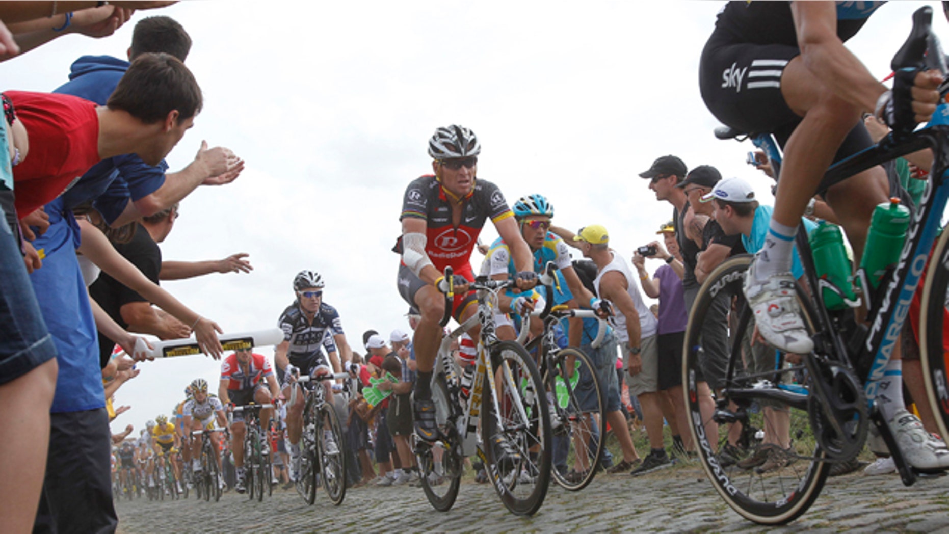 July 6: Lance Armstrong, center, and Alberto Contador of Spain, right of Armstrong, ride on a cobblestone section during the third stage of the Tour de France cycling race over 132.4 miles with start in Wanze, Belgium and finish in Arenberg, France.