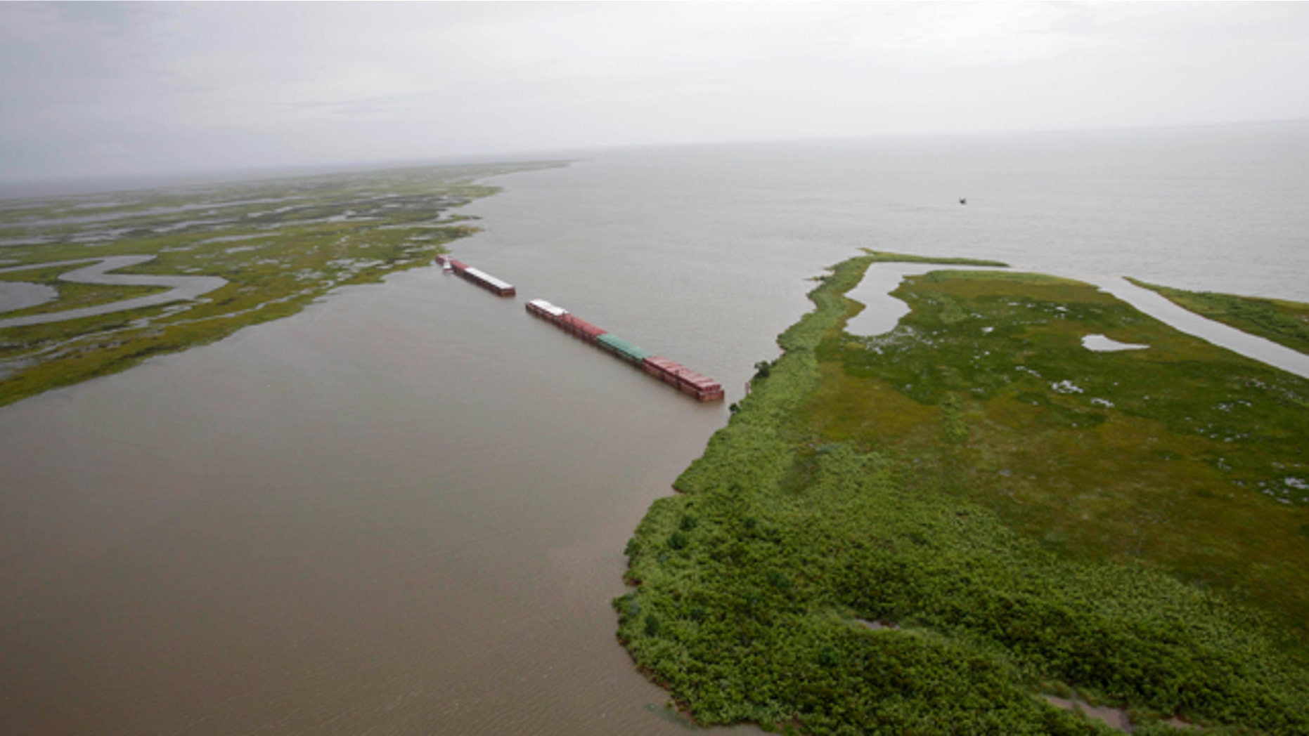 July 6: Barges lined up to block oil are seen from the air in Chef Menteur Pass, which connects the Gulf of Mexico and Lake Borgne to Lake Pontchartrain, in New Orleans, La.