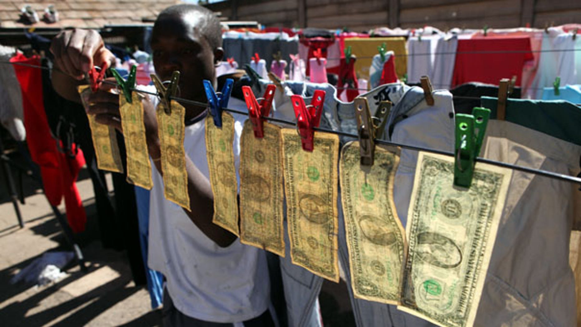 July 6: Alex Mupondi hangs dollar bills on a drying line after washing them in Harare -- Zimbabwe's style of laundering dirty money.