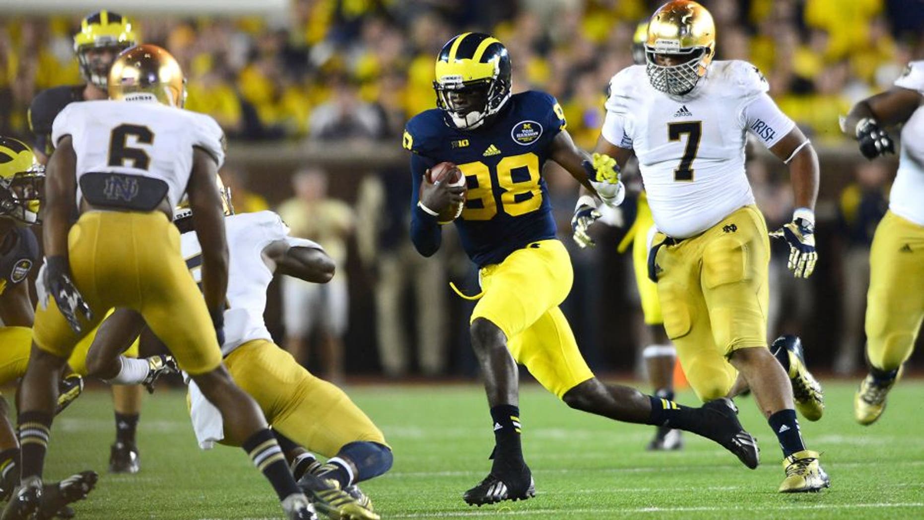 Sep 7, 2013; Ann Arbor, MI, USA; Michigan Wolverines quarterback Devin Gardner (12) runs the ball during the third quarter against the Notre Dame Fighting Irish at Michigan Stadium. Mandatory Credit: Andrew Weber-USA TODAY Sports