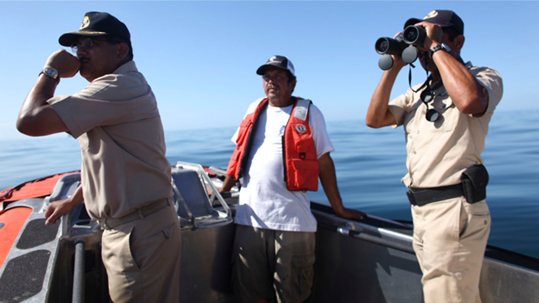 July 6: Fisherman Jesus Rodrigo Fernandez, center, a member of the crew of the fishing boat that capsized last Sunday, helps Navy personnel in the search and rescue efforts in Punta Bufeo.