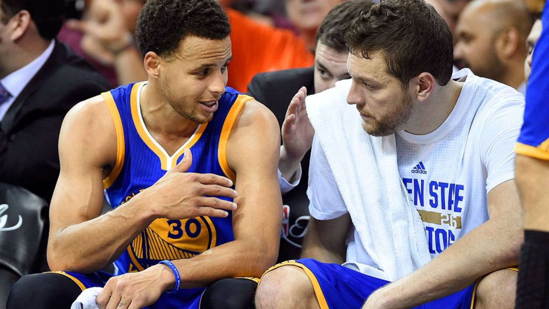 Jun 11, 2015; Cleveland, OH, USA; Golden State Warriors guard Stephen Curry (30) talks to forward David Lee (10) on the bench during the fourth quarter against the Cleveland Cavaliers in game four of the NBA Finals at Quicken Loans Arena. Mandatory Credit: Bob Donnan-USA TODAY Sports