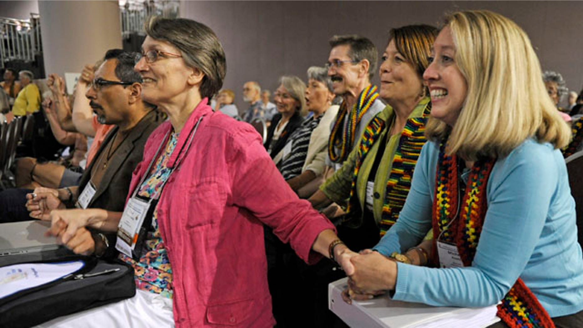 July 8: Observers Tricia Dykes Koenig, left, and Michelle Ready, right, smile as the General Assembly of the Presbyterian Church meeting in Minneapolis votes to approve lifting the churches ban on ordaining non-celebrate gays and lesbians as clergy.