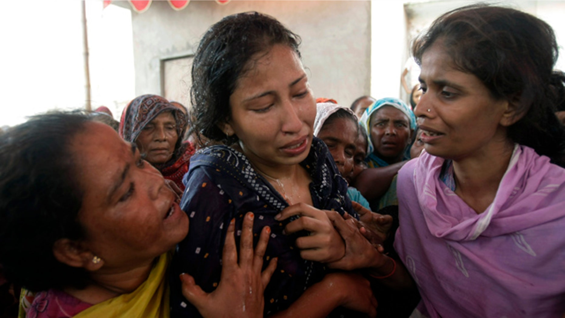 July 8: Women comfort a Pakistani wife who lost her husband after he was fatally shot in Karachi, Pakistan.