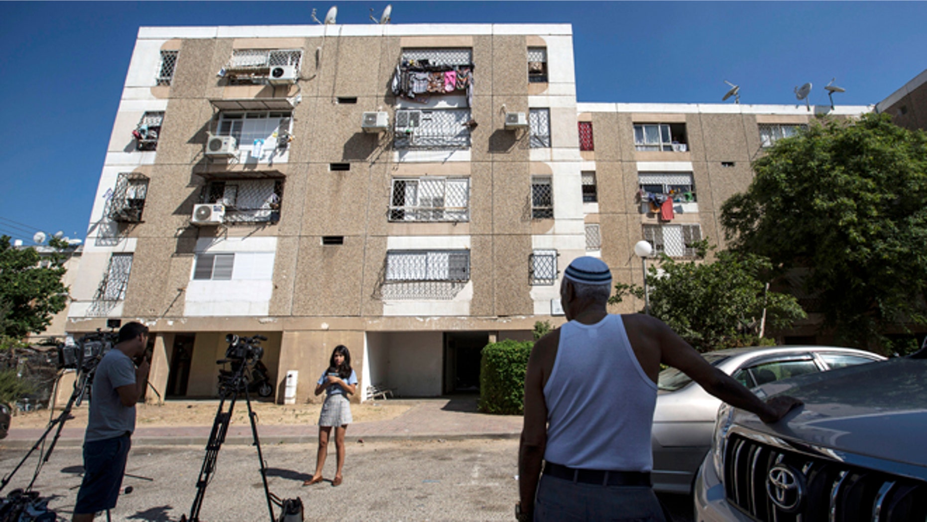 July 9, 2015: Israeli journalists report outside the apartment building of Ethiopian-Israeli Avraham Mengisto, 28, in the costal city of Ashkelon, Israel.