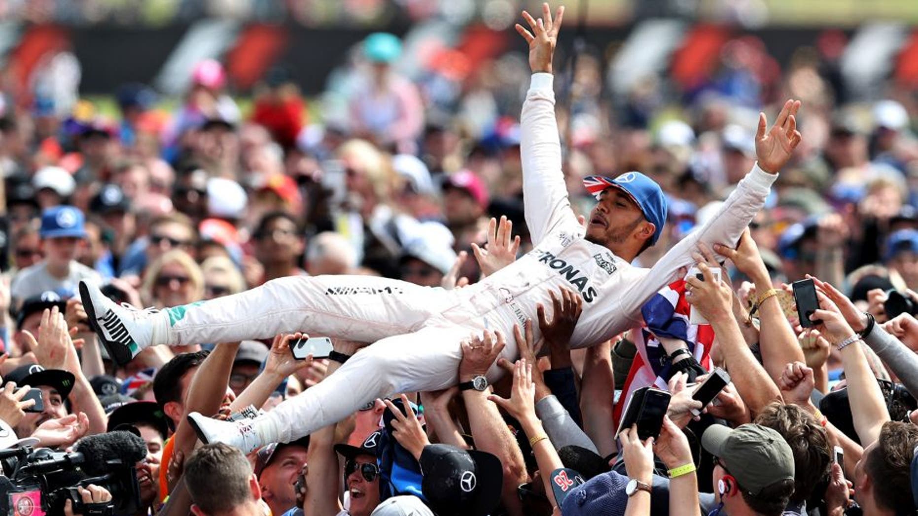 NORTHAMPTON, ENGLAND - JULY 10: Lewis Hamilton of Great Britain and Mercedes GP celebrates his win by crowdsurfing with the fans during the Formula One Grand Prix of Great Britain at Silverstone on July 10, 2016 in Northampton, England. (Photo by Mark Thompson/Getty Images)