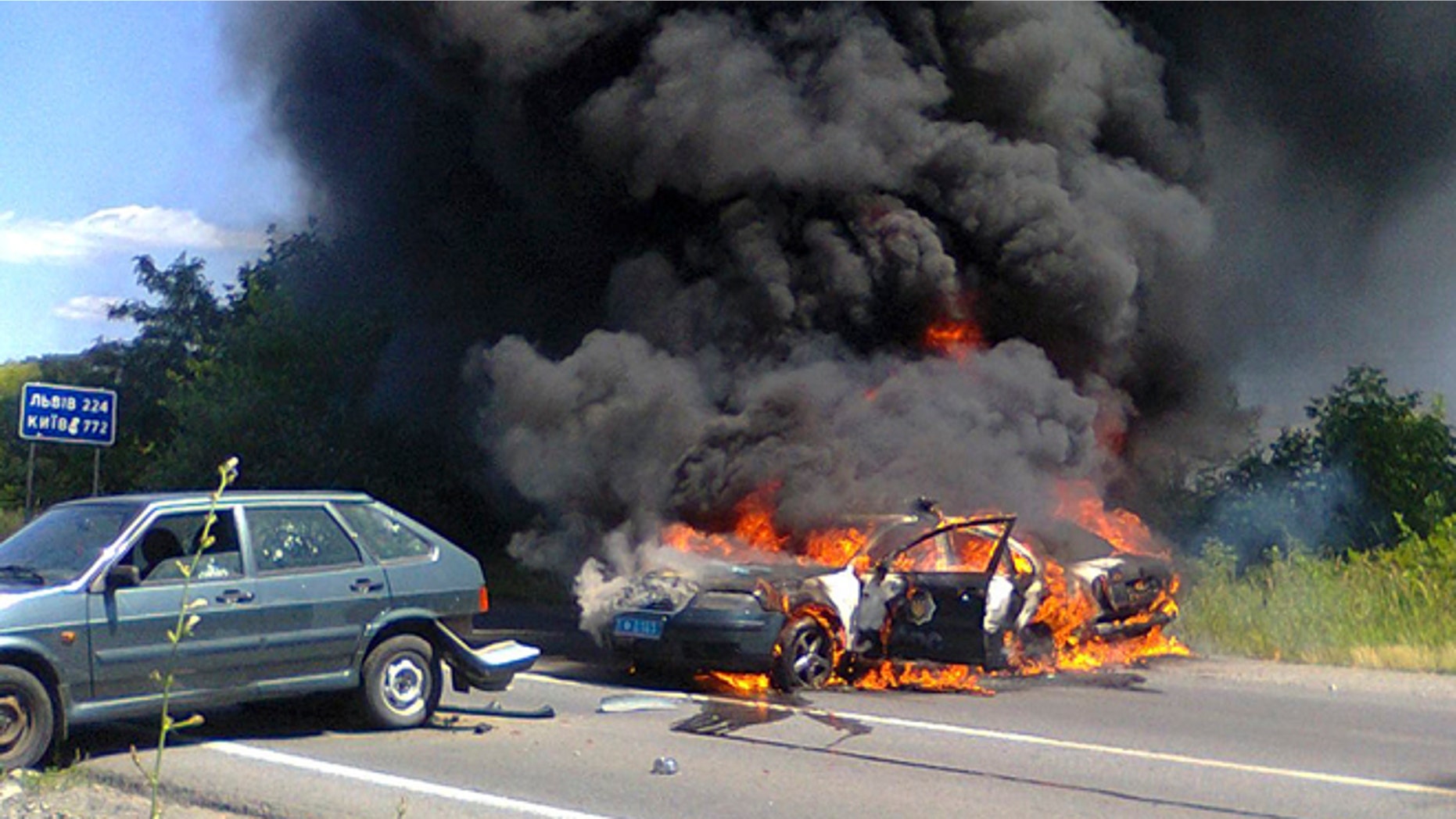 July 11, 2015: Two police cars on fire are seen at the site of unrest in Mukhachevo, Western Ukraine.
