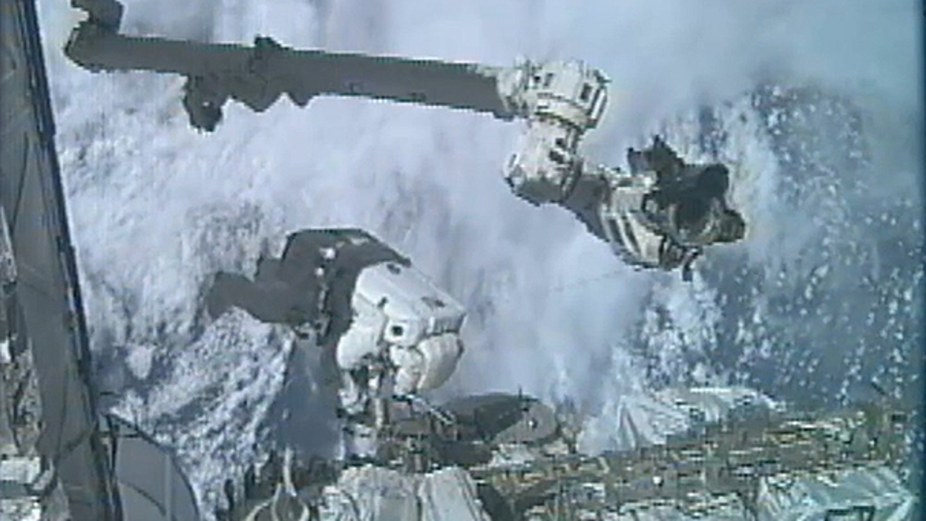 July 12: In an image made from video, astronaut Ronald Garan Jr. dangles outside the International Space Station during the last spacewalk of NASA's space shuttle era, with fellow astronaut Michael Fossum (not shown).