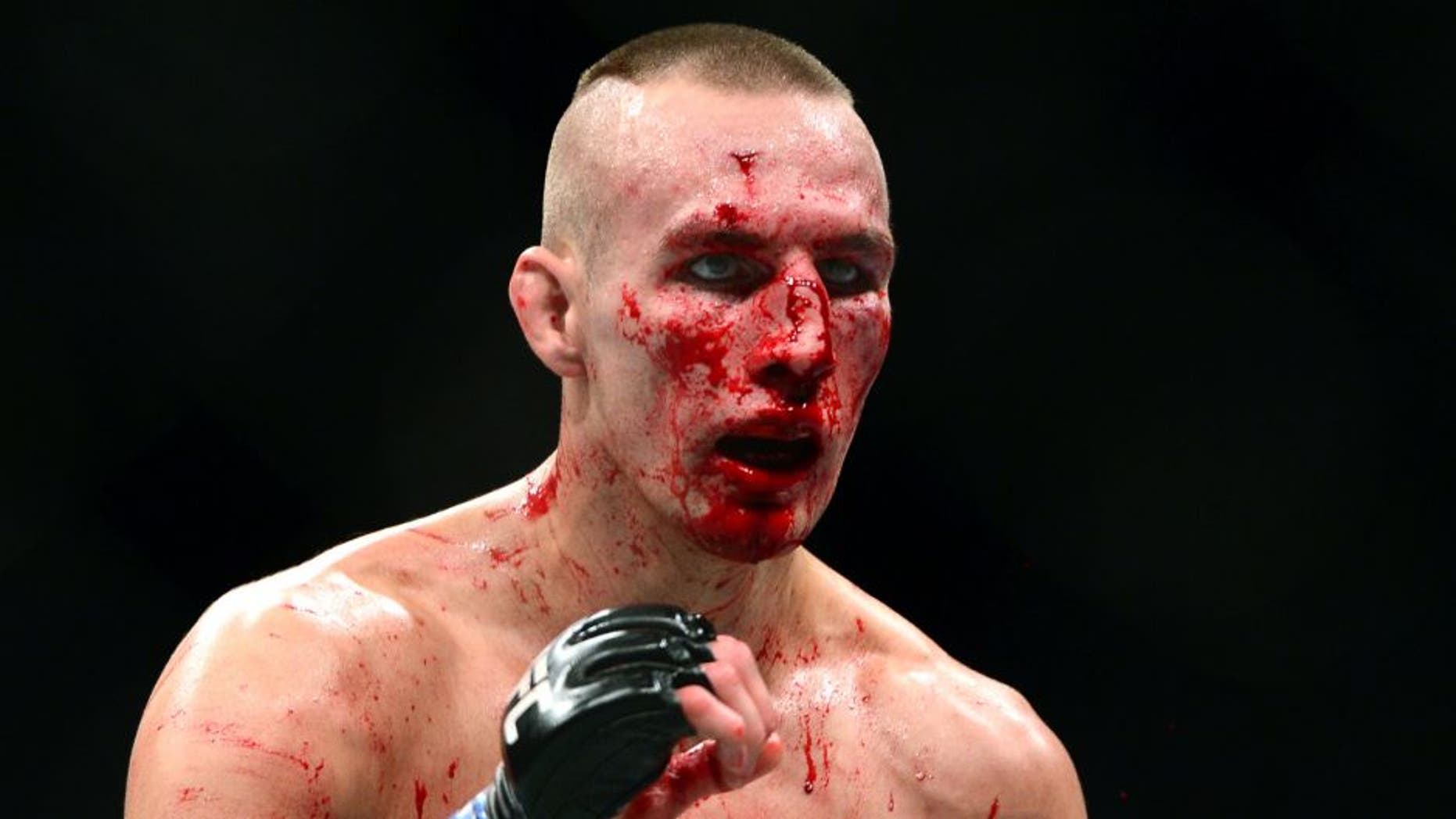 Jul 11, 2015; Las Vegas, NV, USA; Robbie Lawler (not pictured) and Rory MacDonald (blue gloves) fight during their welterweight title bout during UFC 189 at MGM Grand Garden Arena. Lawler won via fifth round TKO. Mandatory Credit: Joe Camporeale-USA TODAY Sports