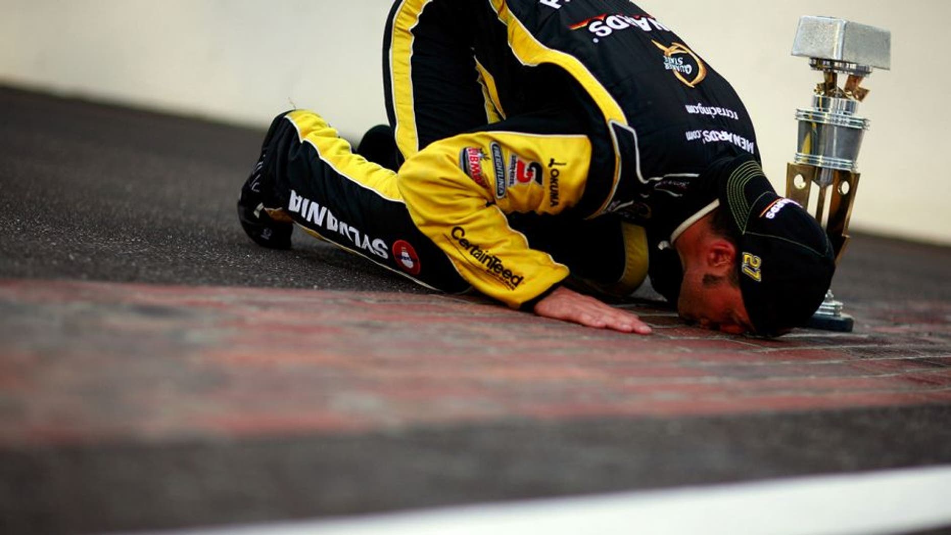 INDIANAPOLIS, IN - JULY 31: Paul Menard, driver of the #27 NIBCO/Menards Chevrolet, poses as he kisses the bricks after winning the NASCAR Sprint Cup Series Brickyard 400 at Indianapolis Motor Speedway on July 31, 2011 in Indianapolis, Indiana. (Photo by Tom Pennington/Getty Images for NASCAR)
