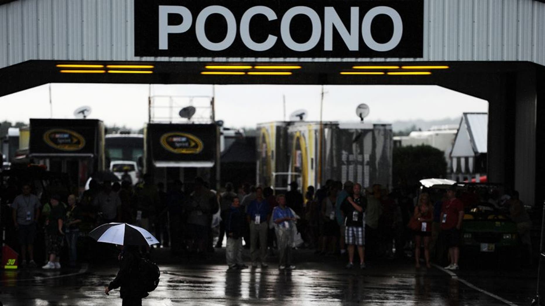 LONG POND, PA - AUGUST 05: A crew member walks through the garage area as rain delays the start of the NASCAR Sprint Cup Series Pennsylvania 400 at Pocono Raceway on August 5, 2012 in Long Pond, Pennsylvania. (Photo by Patrick Smith/Getty Images for NASCAR)