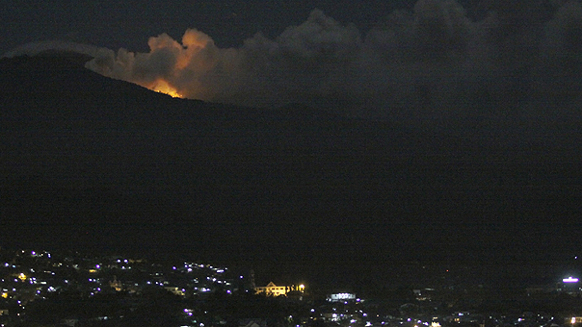 July 15: The glow of lava from Mount Lokon's eruption is seen against the night sky as seen from Manado, North Sulawesi, Indonesia.