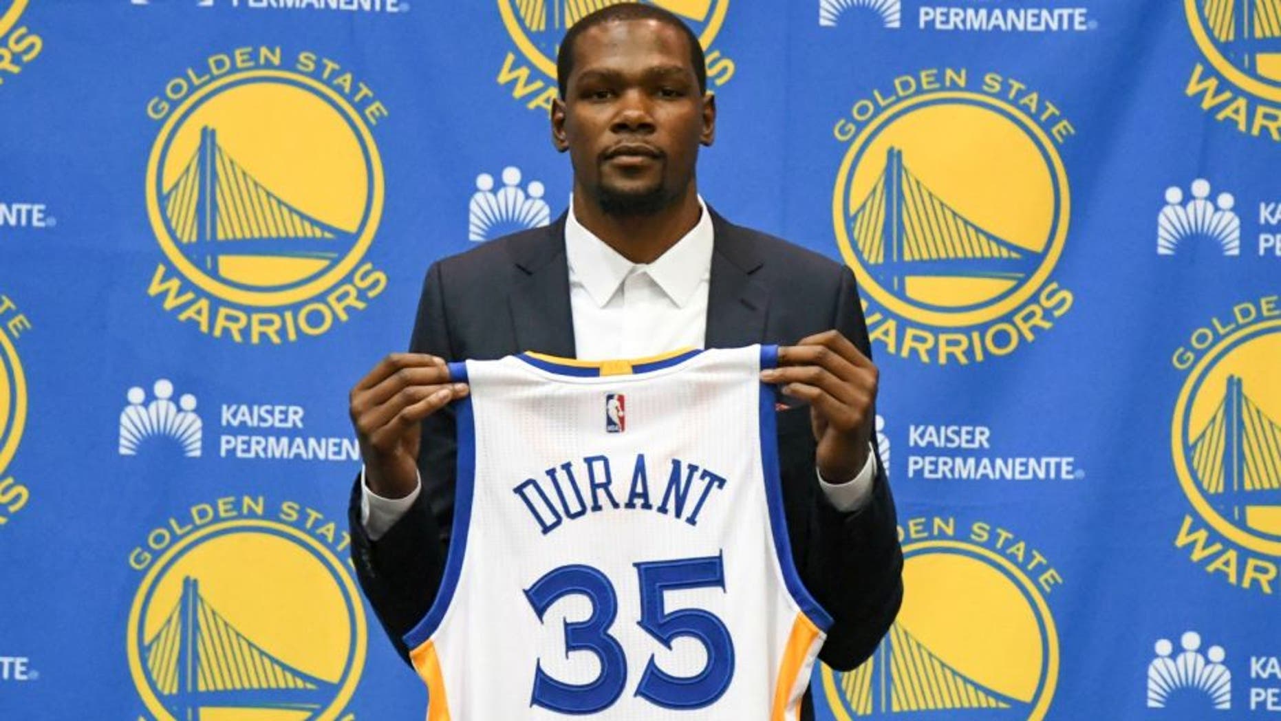 Jul 7, 2016; Oakland, CA, USA; Kevin Durant poses for a photo with his jersey during a press conference after signing with the Golden State Warriors at the Warriors Practice Facility. Mandatory Credit: Kyle Terada-USA TODAY Sports