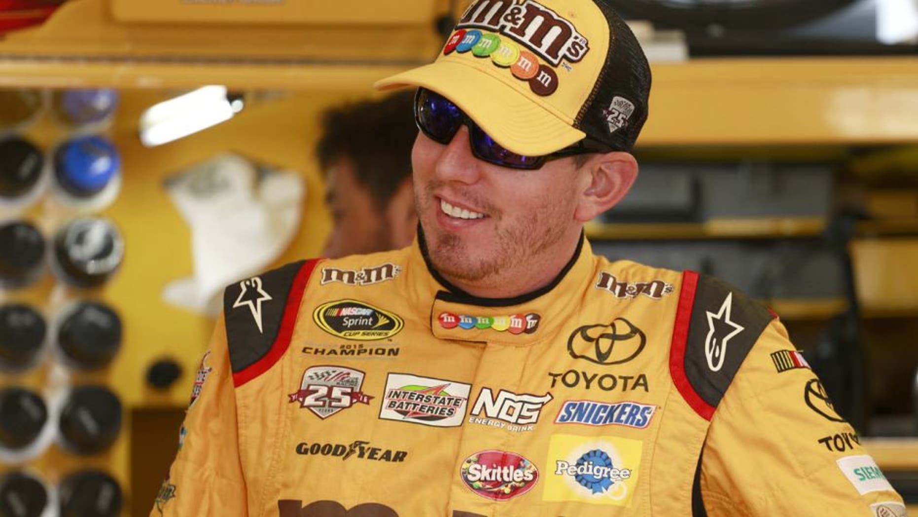 SPARTA, KY - JULY 08: Kyle Busch, driver of the #18 M&M's 75th Anniversary Toyota, stands in the garage area during practice for the NASCAR Sprint Cup Series Quaker State 400 at Kentucky Speedway on July 8, 2016 in Sparta, Kentucky. (Photo by Matt Sullivan/Getty Images)