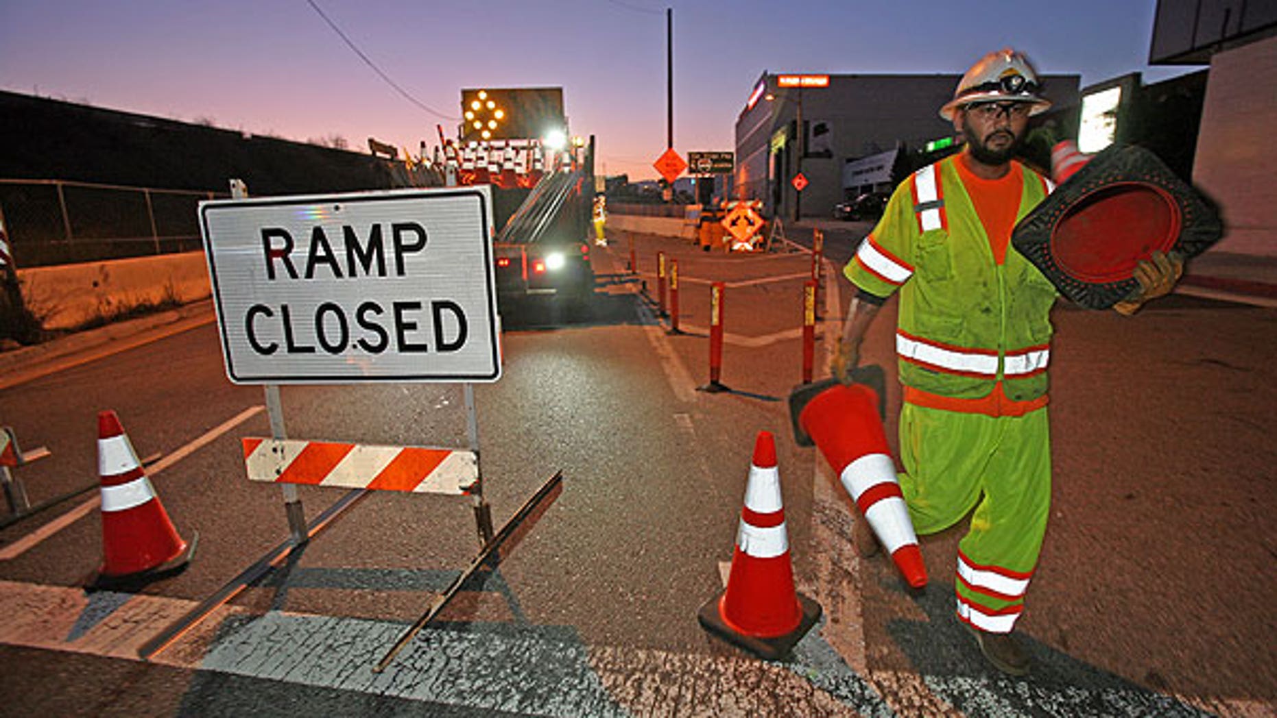 July 16: A construction worker places orange cones to close the ramp of Interstate 405 freeway at Santa Monica Boulevard in Los Angeles.