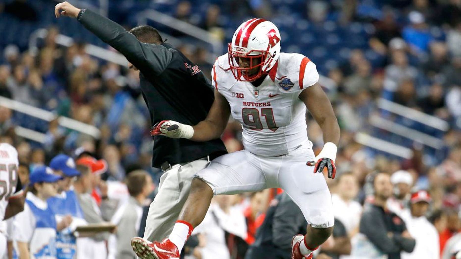 Rutgers Darius Hamilton celebrates with defensive coordinator Joe Rossi after a hard hit on UNC quarterback Marquise Williams as Rutgers defeats North Carolina 40-21 in the Quick Lane Bowl at Ford Field. 12/26/14 Detroit, MI (John Munson | NJ Advance Media for NJ.com)