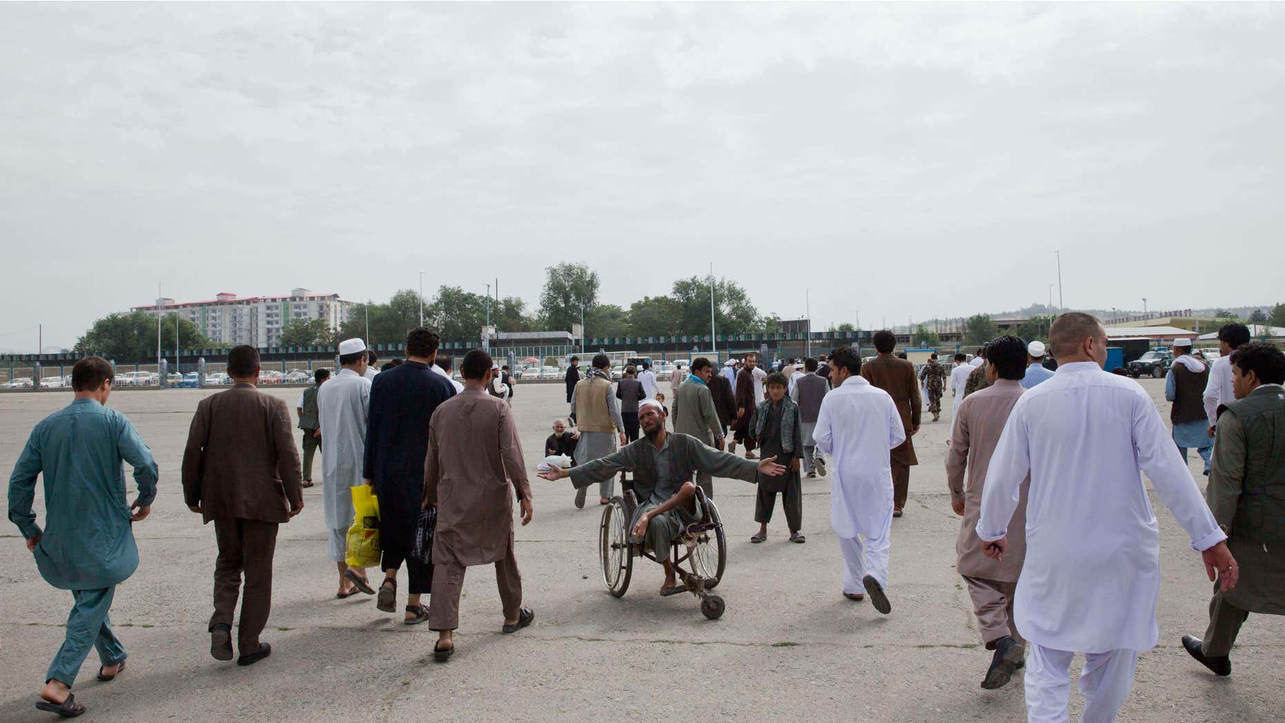 July 17, 2015: An Afghan begger, center, asks for money after Eid al-Fitr prayers in Eid Gah mosque in Kabul, Afghanistan.