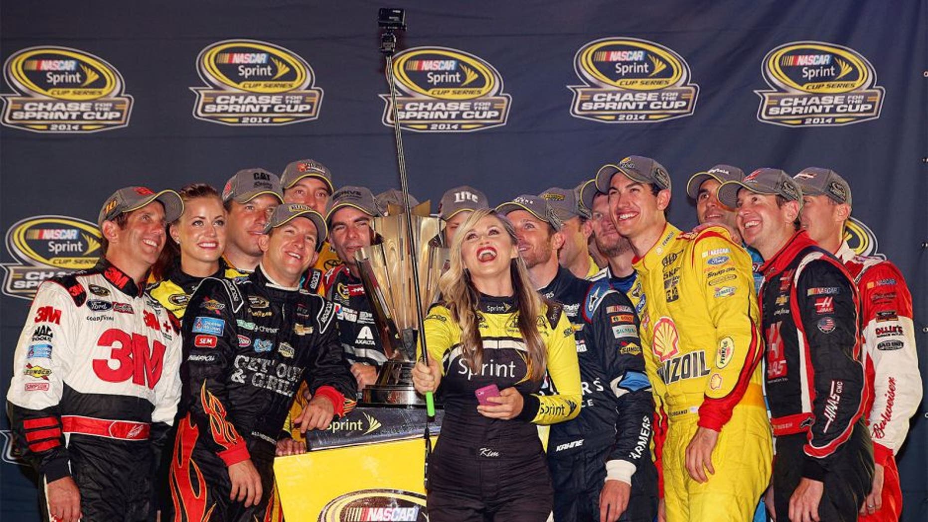 RICHMOND, VA - SEPTEMBER 06: Miss Sprint Cup Kim Coon takes a selfie with Chase for the Sprint Cup qualifiers Jeff Gordon, driver of the #24 Drive to End Hunger Chevrolet, Kyle Busch, driver of the #18 M&M's Toyota, Carl Edwards, driver of the #99 Kelloggs/Frosted Flakes Ford, Ryan Newman, driver of the #31 Catepillar Chevrolet, Miss Sprint Cup Madison Martin, Miss Sprint Cup Kim Coon, Dale Earnhardt Jr., driver of the #88 Nationwide Insurance Chevrolet, Matt Kenseth, driver of the #20 Dollar General Toyota, Aric Almirola, driver of the #43 Gwaltney Ford, Brad Keselowski, driver of the #2 Miller Lite Ford, Denny Hamlin, driver of the #11 FedEx Express Toyota, Greg Biffle, driver of the #16 3M Call Before You Dig Ford, AJ Allmendinger, driver of the #47 Bush's Beans Chevrolet, Kasey Kahne, driver of the #5 Farmers Insurance Chevrolet, Joey Logano, driver of the #22 Shell-Pennzoil Ford, Kurt Busch, driver of the #41 Haas Automation Chevrolet, and Kevin Harvick, driver of the #4 Budweiser Chevrolet, after qualifying for the Chase for the Sprint Cup during the NASCAR Sprint Cup Series Federated Auto Parts 400 at Richmond International Raceway on September 6, 2014 in Richmond, Virginia. (Photo by Chris Graythen/NASCAR via Getty Images)
