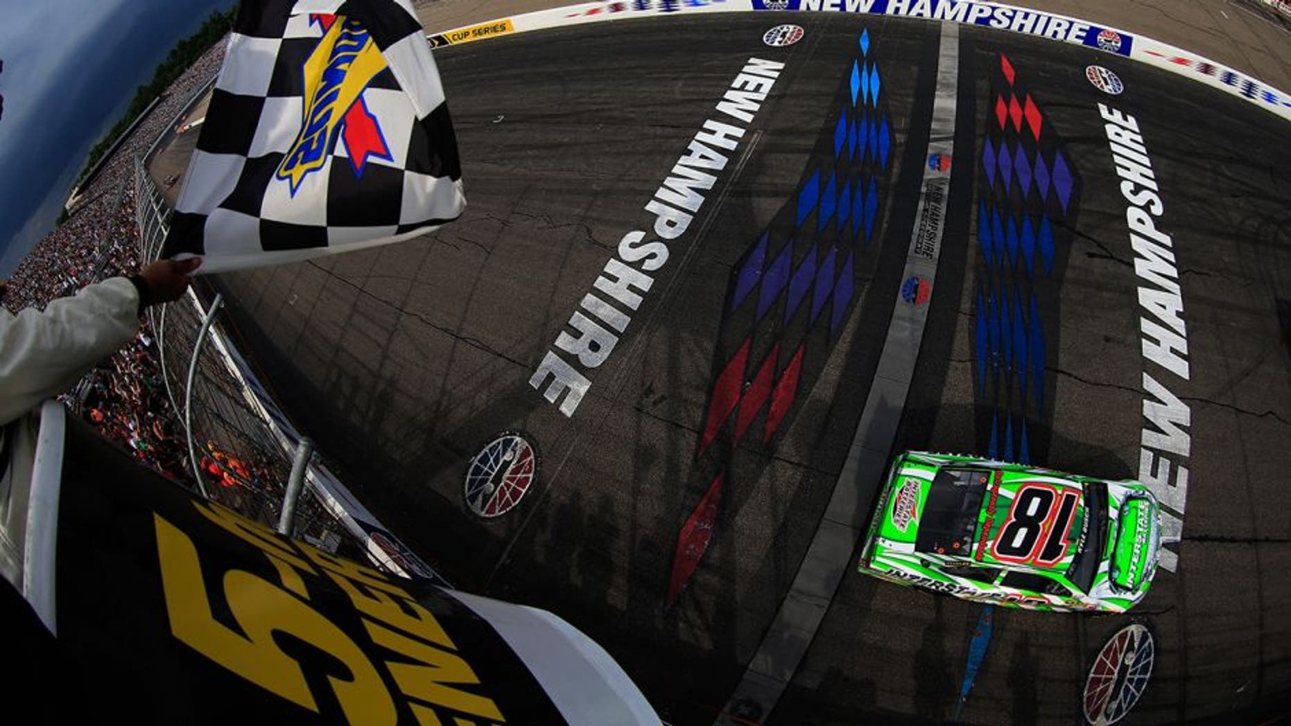 LOUDON, NH - JULY 19: Kyle Busch, driver of the #18 Interstate Batteries Toyota, takes the checkered flag to win the NASCAR Sprint Cup Series 5-Hour ENERGY 301 at New Hampshire Motor Speedway on July 19, 2015 in Loudon, New Hampshire. (Photo by Chris Trotman/NASCAR via Getty Images)