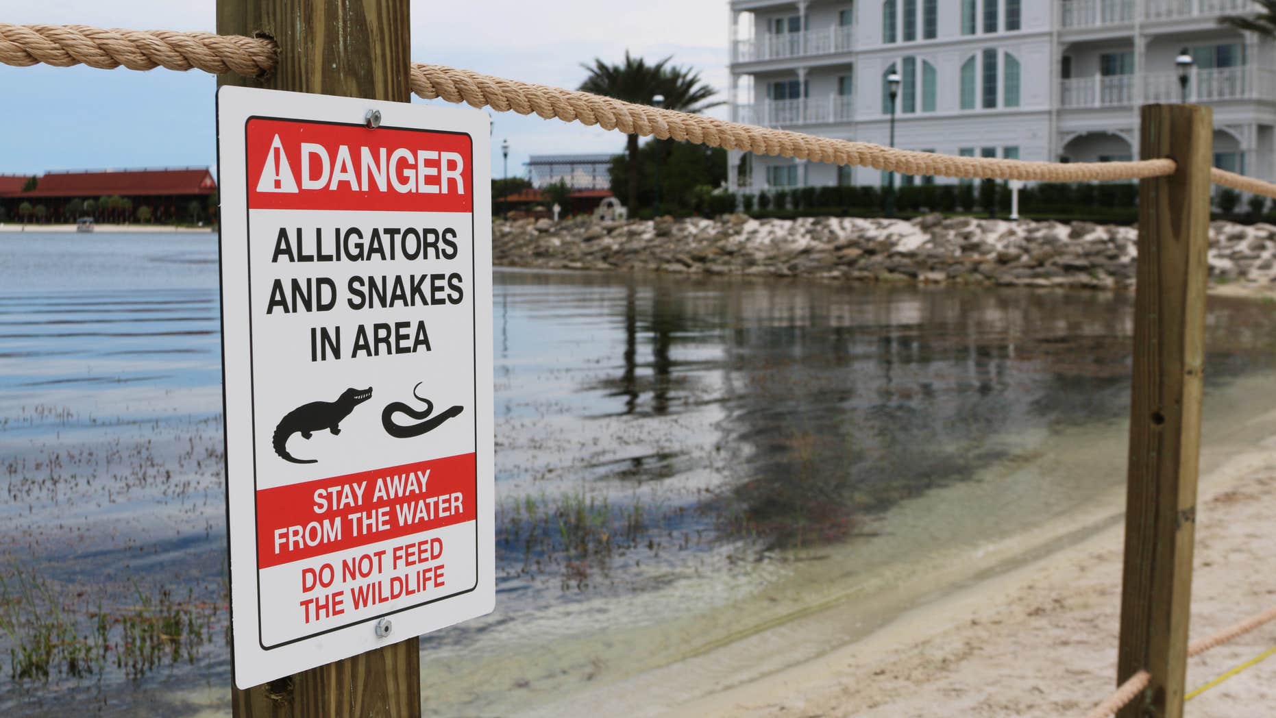 FILE - In this Friday, June, 17, 2016 file photo released by Walt Disney World Resort, a new sign is seen posted on a beach outside a hotel at a Walt Disney World resort in Lake Buena Vista, Fla., after a 2-year-old Nebraska boy killed by an alligator at Disney World.