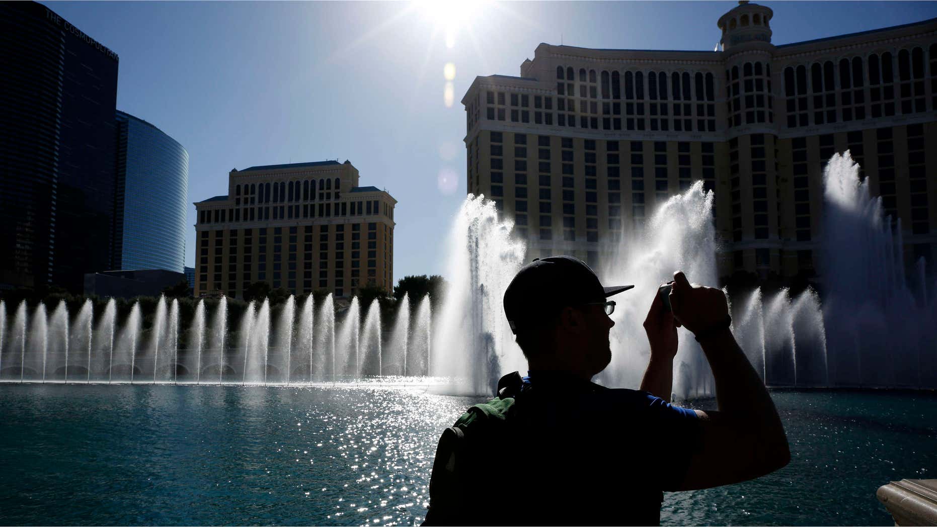 April 15, 2015: A man takes a picture of the fountains in front of the Bellagio hotel and casino in Las Vegas.