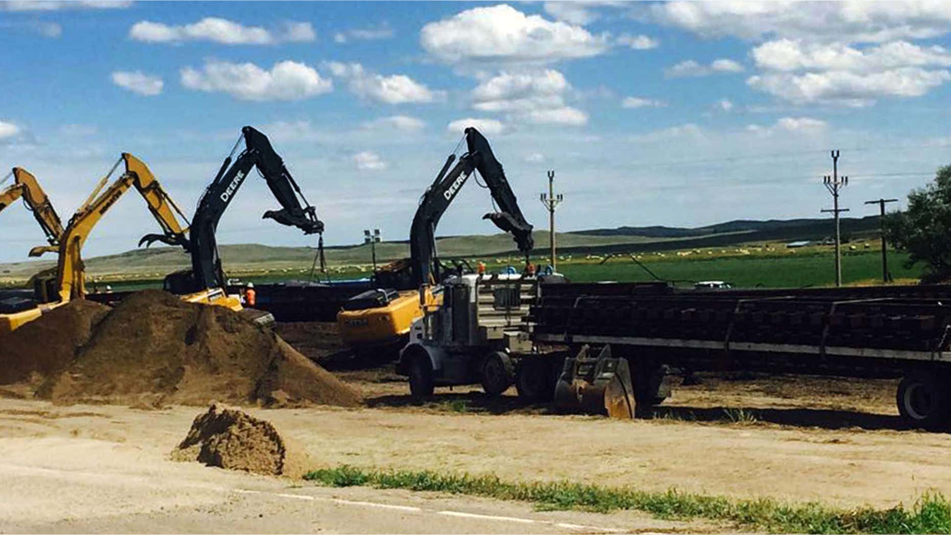 July 17, 2015: Crews with cranes attempt to raise derailed oil tanker cars near Culbertson, Mont.