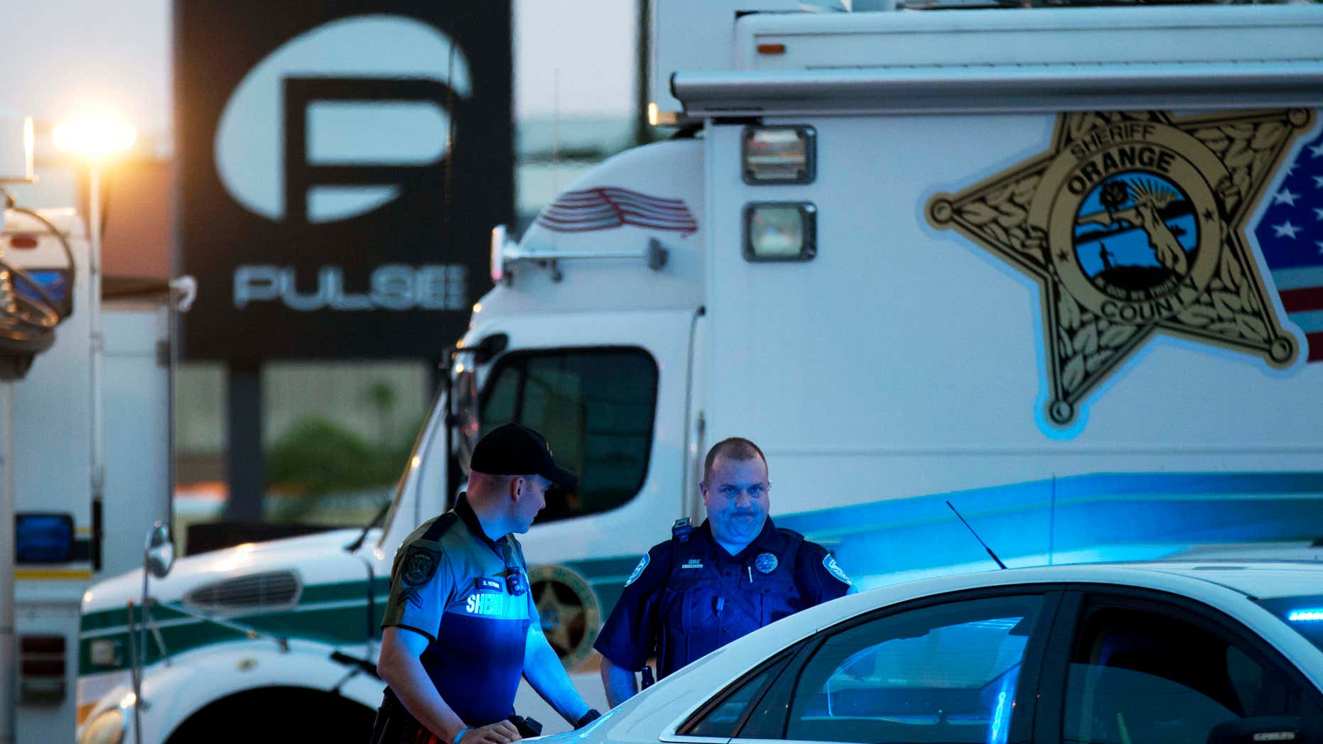 FILE - In this June 17, 2016 file photo, law enforcement officials stand outside the Pulse nightclub following Sunday's mass shooting, in Orlando, Fla.