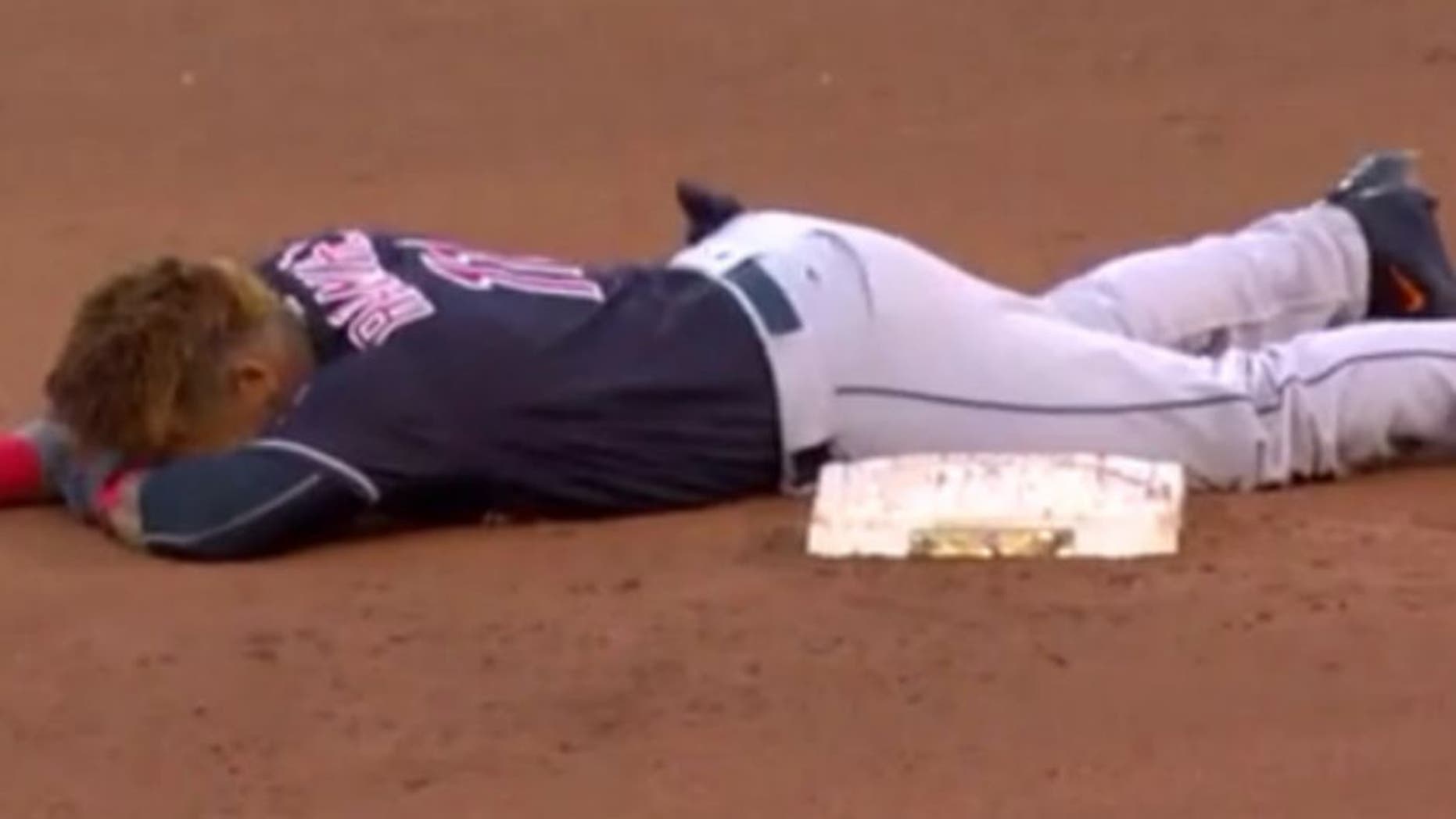 The Indians' Jose Ramirez slides face-first into second base.