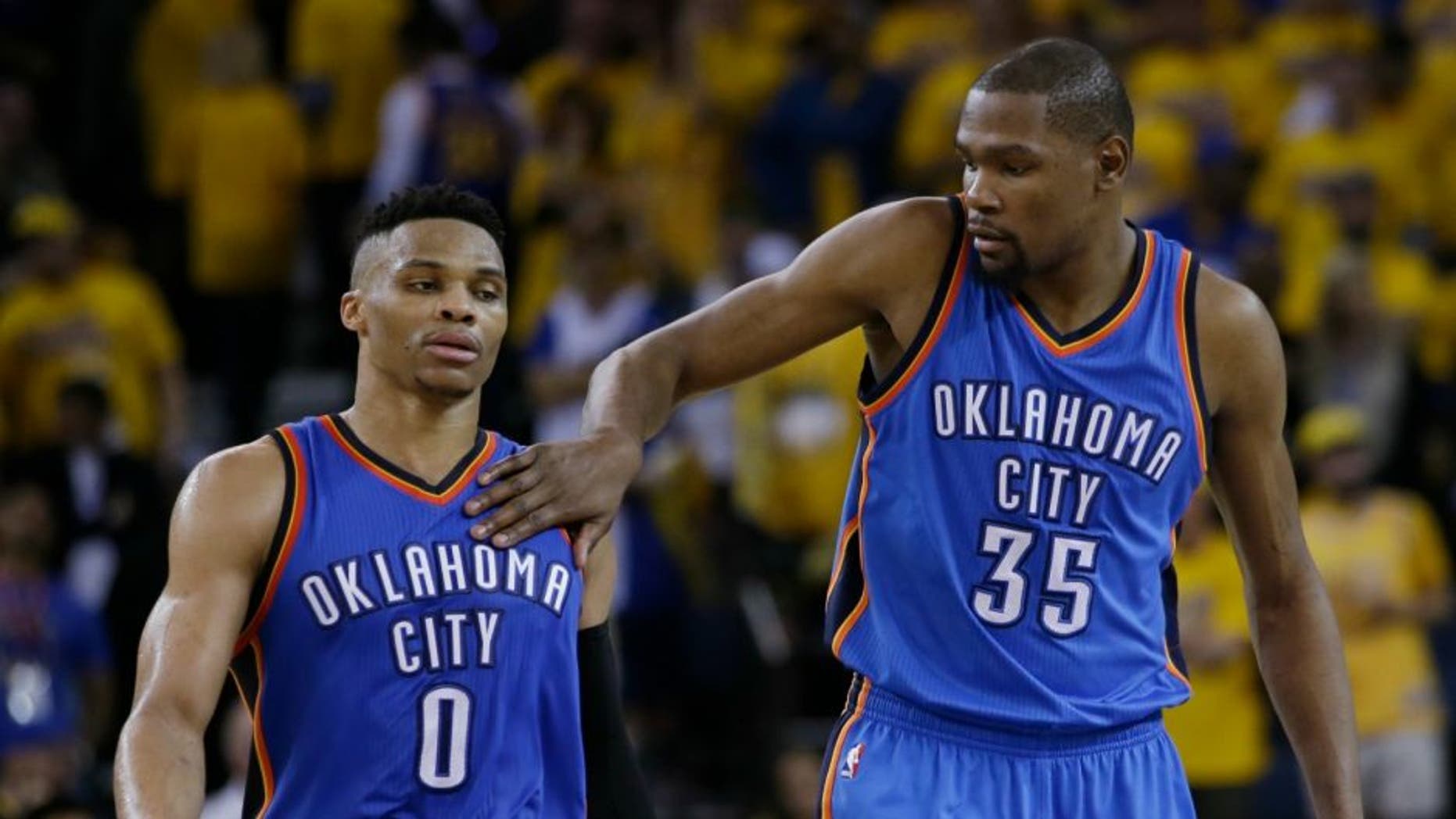 Oklahoma City Thunder's Kevin Durant (35) pats teammate Russell Westbrook (0) on the shoulder as they take a lead over the Golden State Warriors during the second half in Game 1 of the NBA basketball Western Conference finals Monday, May 16, 2016, in Oakland, Calif. Oklahoma City won 108-102. (AP Photo/Marcio Jose Sanchez)