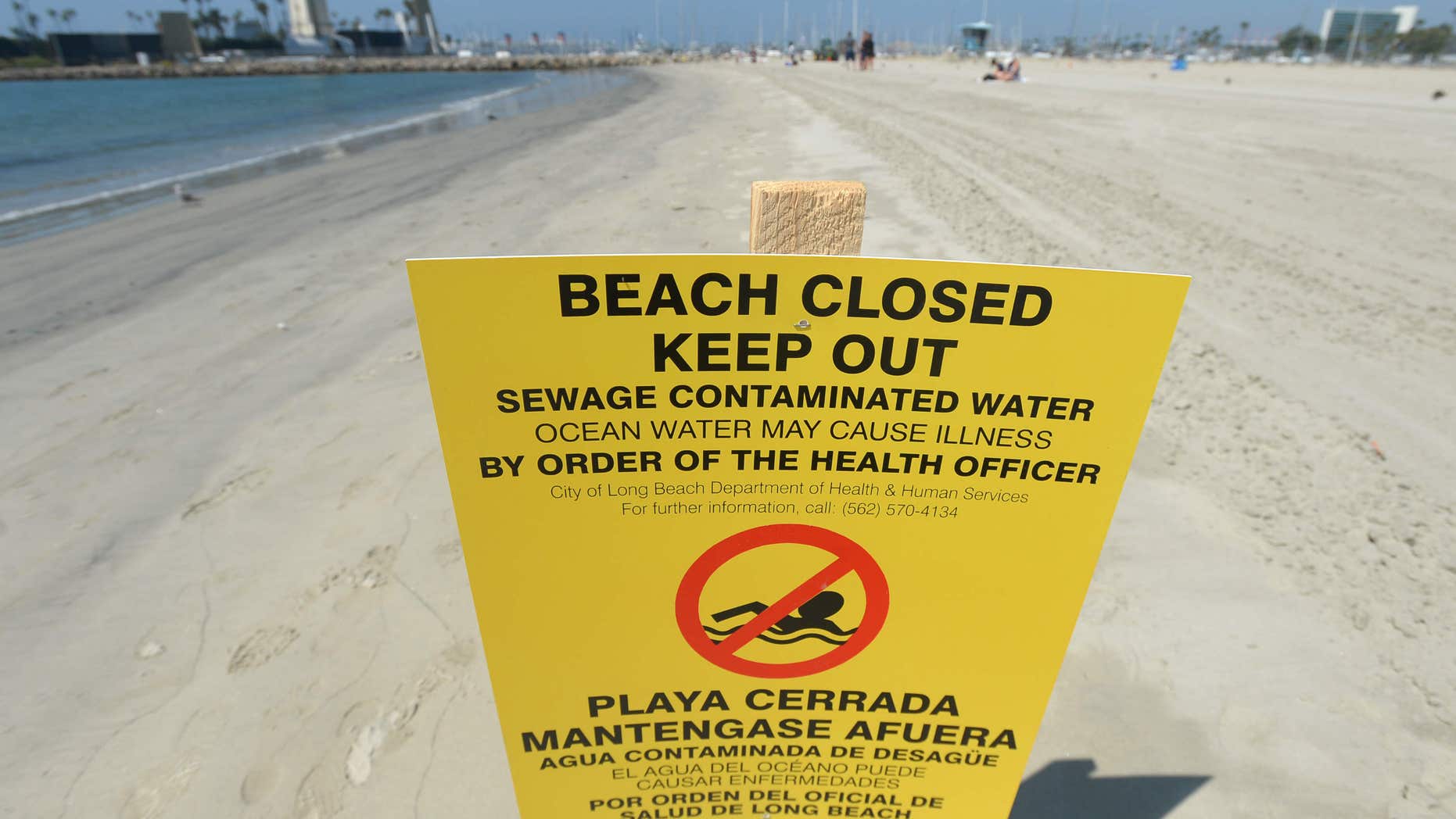 A sign is posted at Alamitos Beach warning of the dangers of sewage contaminated water Tuesday, July 19, 2016, in Long Beach, Calif.