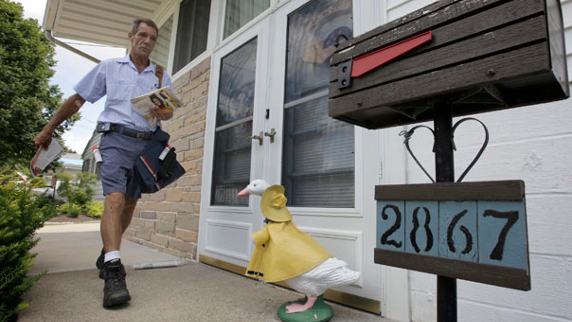 July 16: Ohio letter carrier Keith McVey walks his route delivering mail in Akron, Ohio. The veteran mailman has gained a heroic reputation for delivering people from life-threatening situations three separate times while on the job delivering mail.