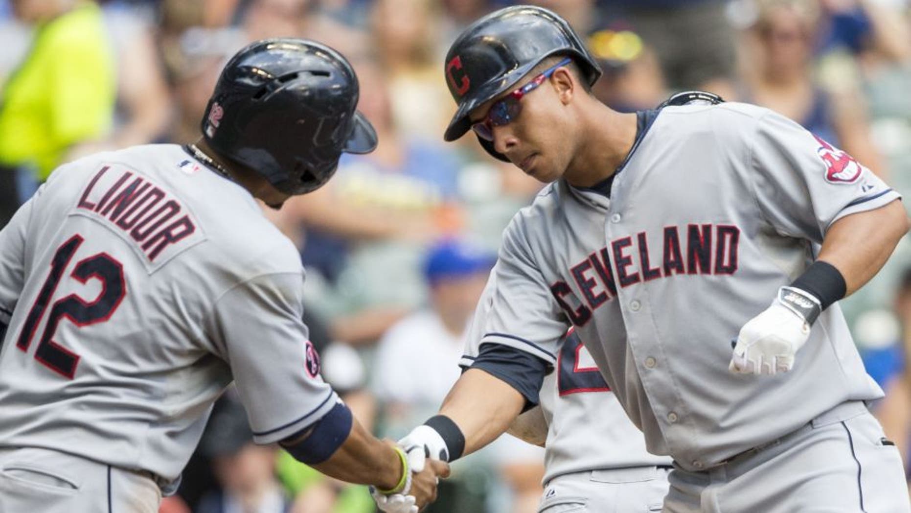Cleveland Indians' Michael Brantley, right, shakes hands with teammate Francisco Lindor after hitting a three-run hom run off Milwaukee Brewers' Kyle Lohse during the third inning of a baseball game Wednesday, July 22, 2015, in Milwaukee.