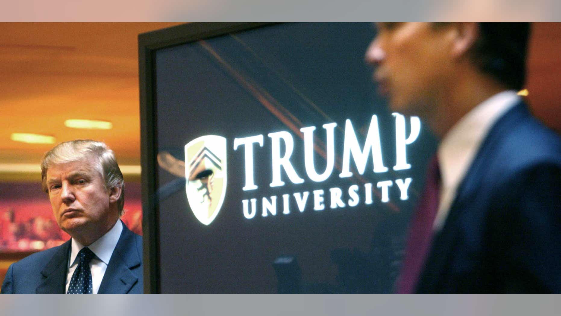 FILE- In this May 23, 2005 file photo, real estate mogul and Reality TV star Donald Trump, left, listens as Michael Sexton introduces him at a news conference in New York where he announced the establishment of Trump University.