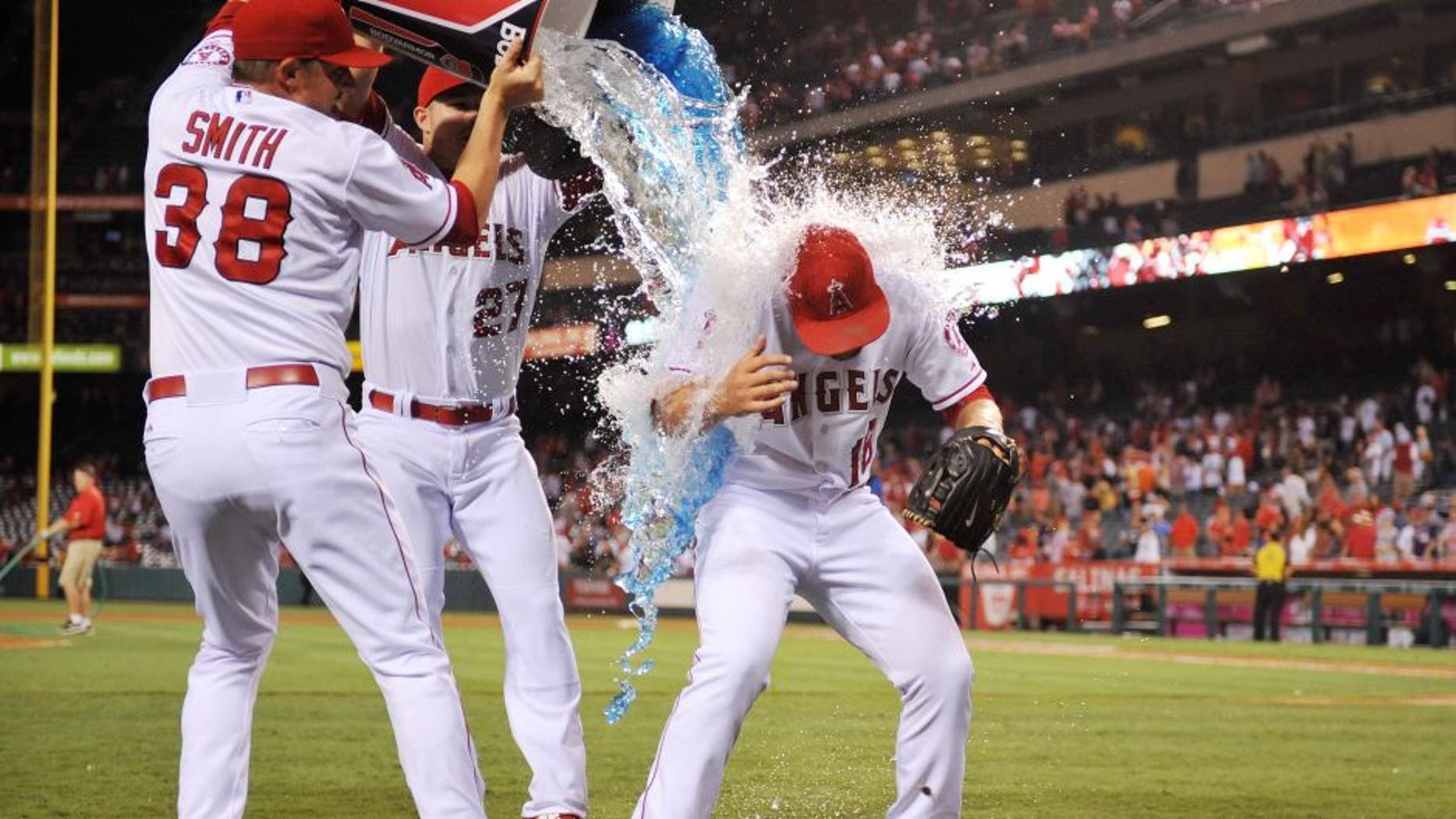 July 22, 2015; Anaheim, CA, USA; Los Angeles Angels relief pitcher Joe Smith (38) and center fielder Mike Trout (27) pour sport drink on relief pitcher Huston Street (16) in celebration of his 300th career save against the Minnesota Twins at Angel Stadium of Anaheim. Mandatory Credit: Gary A. Vasquez-USA TODAY Sports