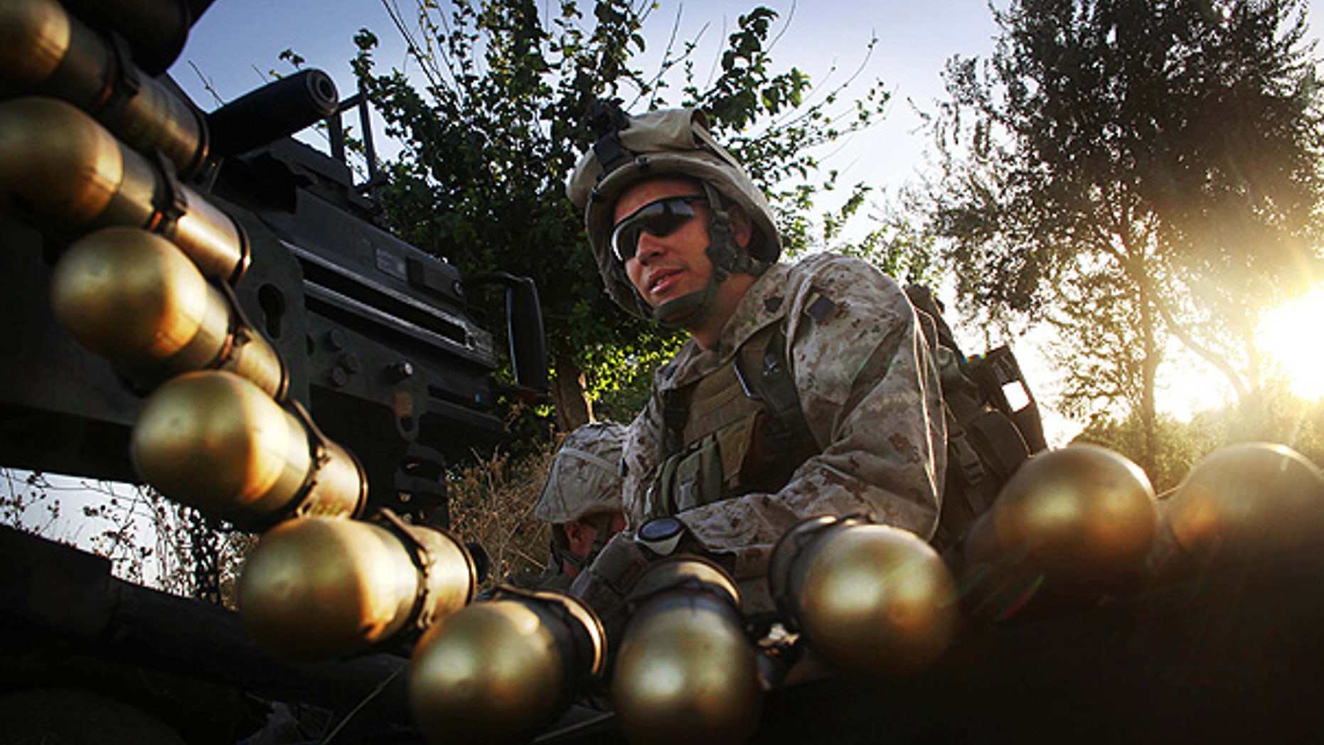 July 21: U.S. Marine Sgt. Adam Wilson mans a Mark 19 heavy gun at a fire position in northern Helmand Province, Afghanistan.