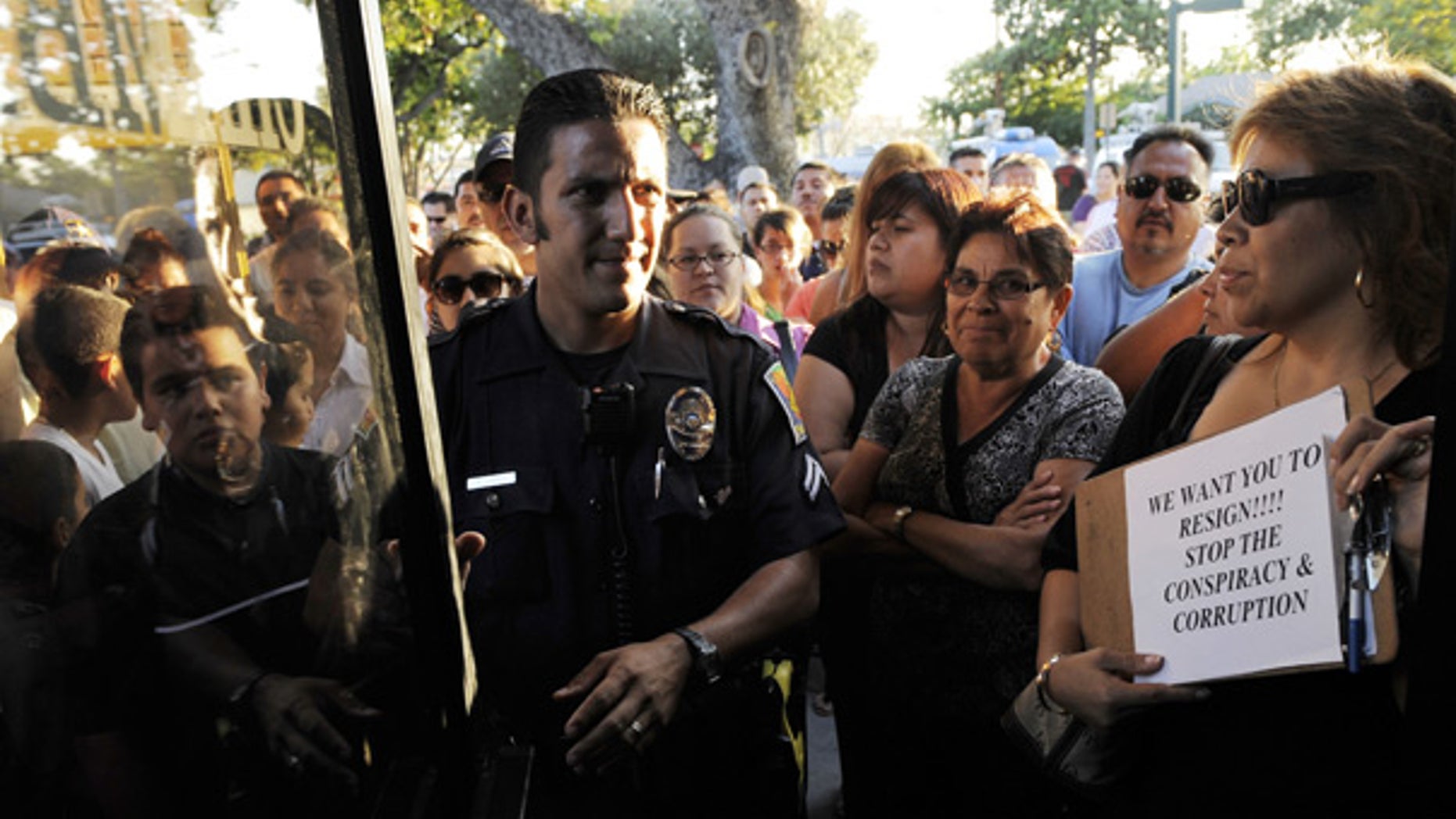 July 22: A Bell police officer patrols outside a special city council meeting to consider the firing of top officials in Bell, Calif.