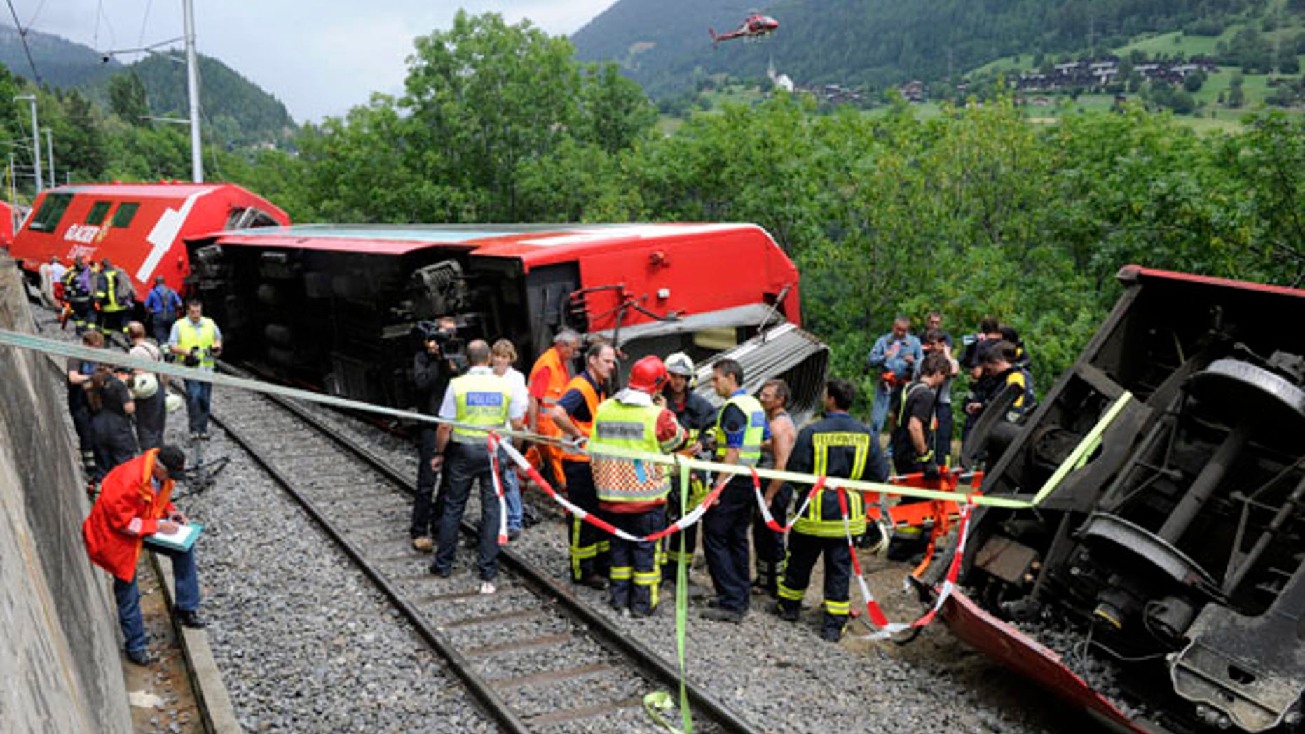 July 23: Rescue workers survey the damaged carriages of a Glacier Express passenger train after the trouist train derailed in Fiesch, Switzerland, killing one passenger and injuring more than 40.