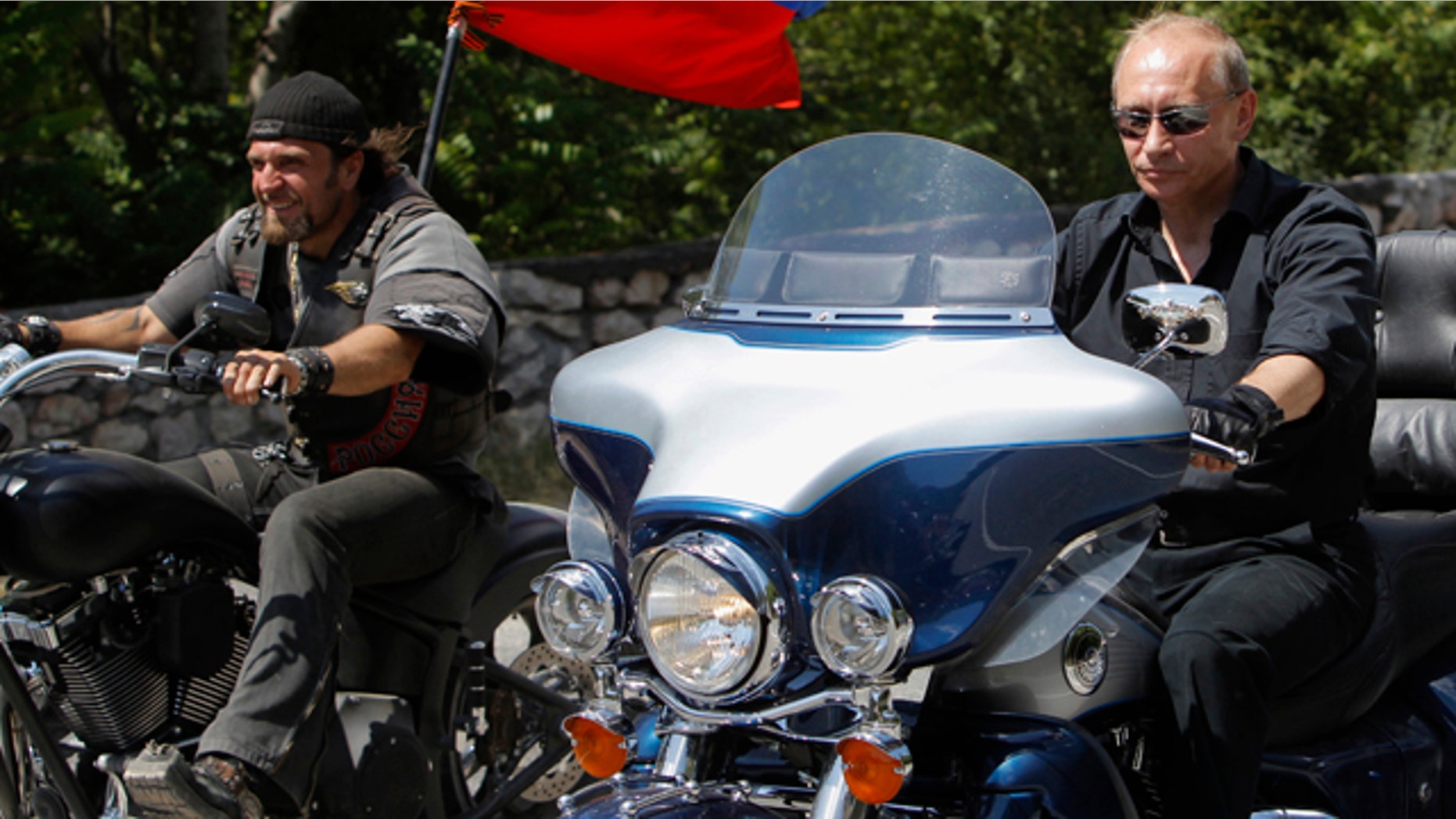 Russia's Prime Minister Vladimir Putin, right, rides Harley Davidson Lehman Trike as he arrives for the meeting with Russian and Ukrainian motorbikers at their camp near Sevastopol in Ukraine's Crimea Peninsula, Saturday, July 24, 2010. Russian flag is in the background. Putin has lept on a Harley Davidson and roared into a international biker convention in southern Ukraine. Around 5,000 bikers from Europe and beyond are gathered in Sevastopol for the annual festival on Ukraine's Crimea peninsula. (AP Photo/Sergei Karpukhin, Pool)