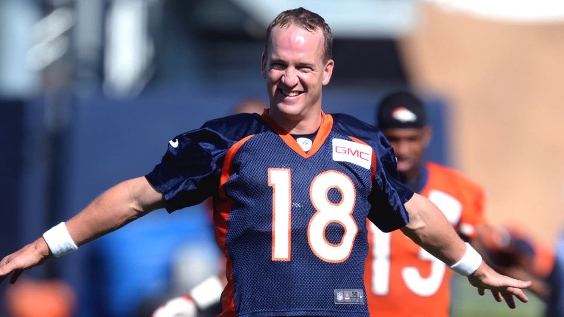 Jul 24, 2014; Dove Valley, CO, USA; Denver Broncos quarterback Peyton Manning (18) warms up during training camp activities at the Broncos training facility. Mandatory Credit: Ron Chenoy-USA TODAY Sports
