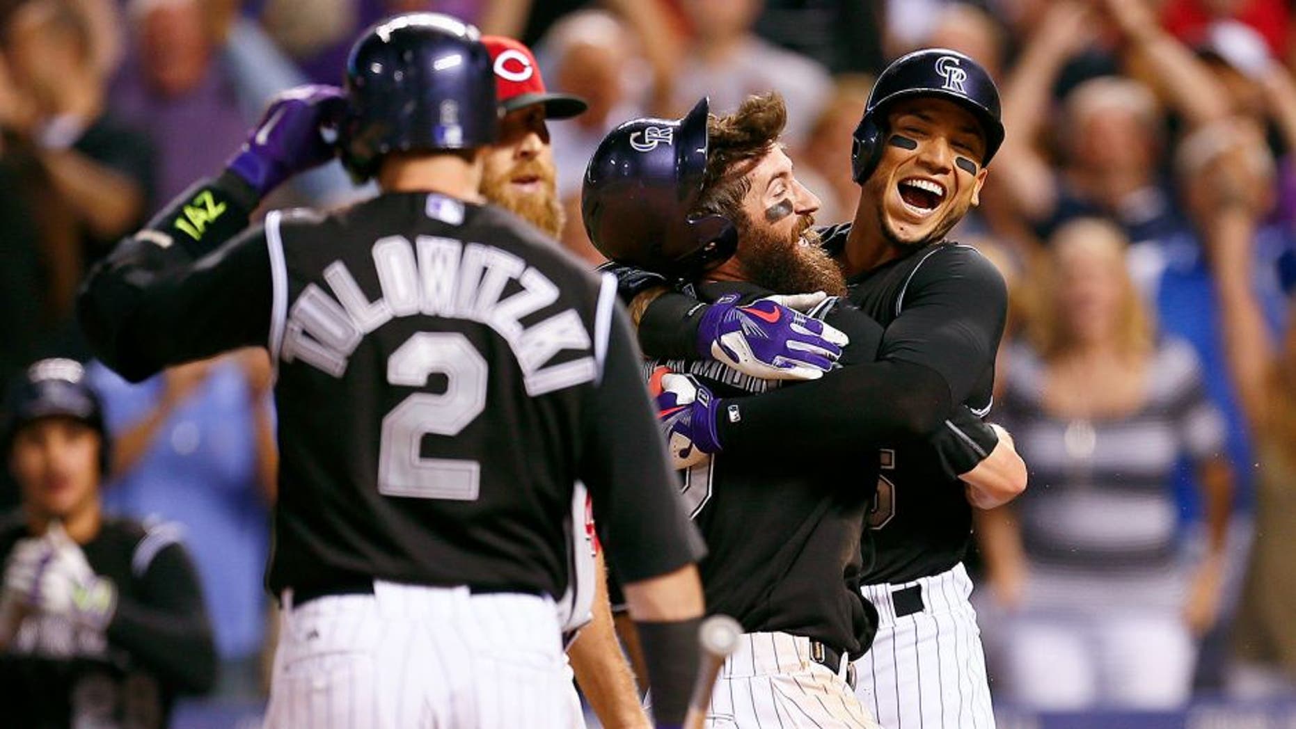 Jul 24, 2015; Denver, CO, USA; Colorado Rockies right fielder Carlos Gonzalez (5) hugs center fielder Charlie Blackmon (19) after his game winning run in the ninth inning against the Cincinnati Reds at Coors Field. Mandatory Credit: Isaiah J. Downing-USA TODAY Sports