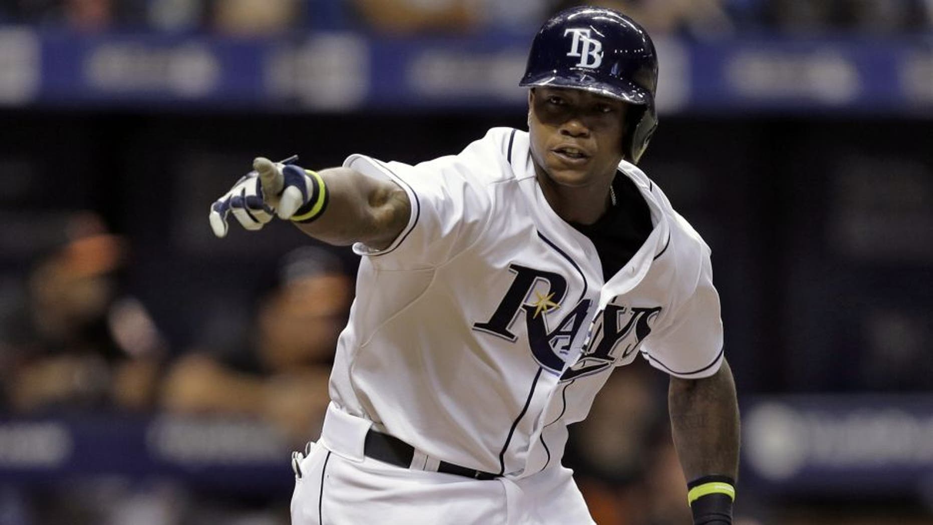 Tampa Bay Rays' Tim Beckham points into the dugout as he runs to first base after hitting a two-run single off Baltimore Orioles relief pitcher Darren O'Day during the eighth inning of a baseball game Friday, July 24, 2015, in St. Petersburg, Fla. Rays' John Jaso and Evan Longoria scored on the play. (AP Photo/Chris O'Meara)