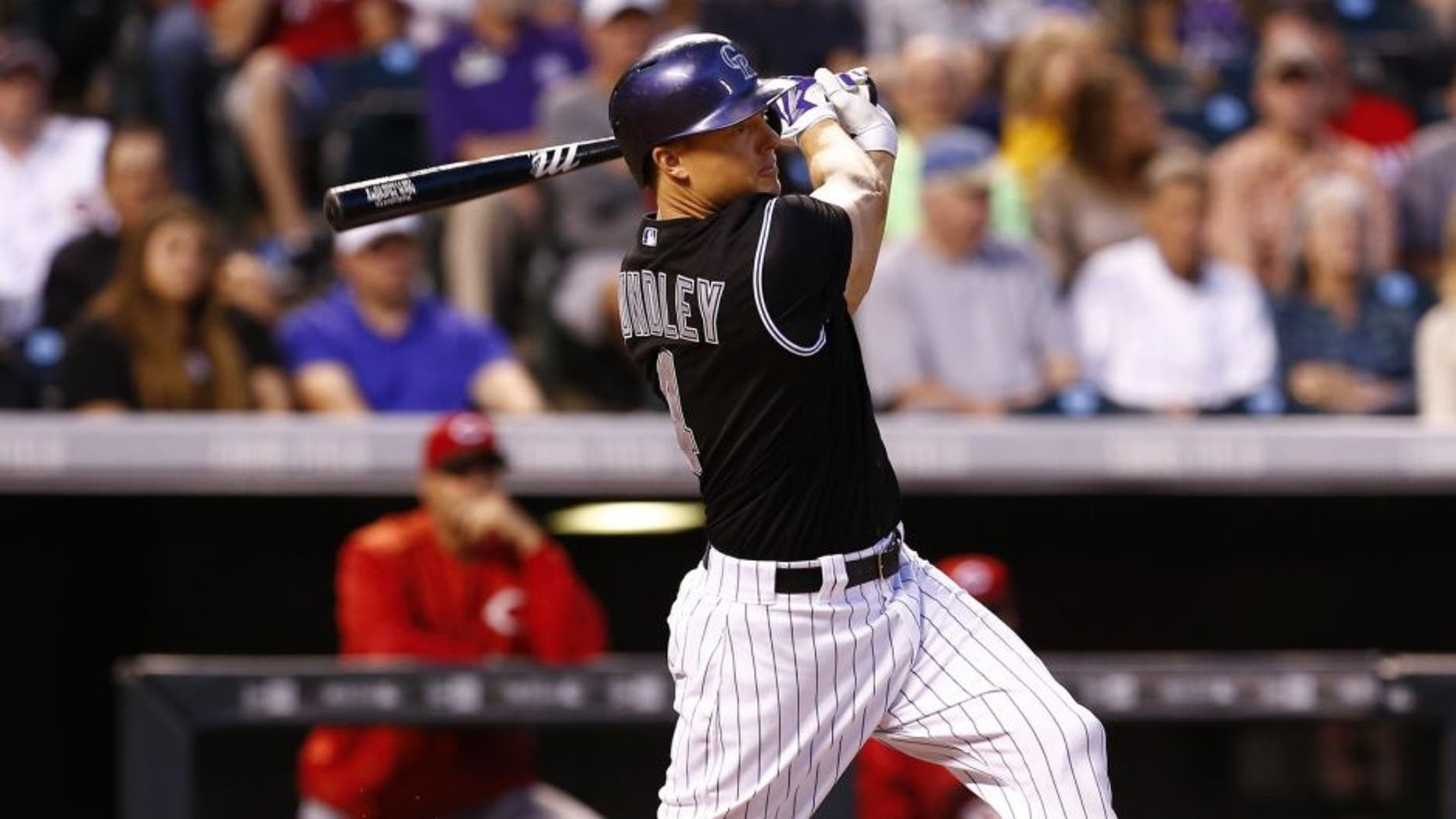 Jul 24, 2015; Denver, CO, USA; Colorado Rockies catcher Nick Hundley (4) hits an RBI triple in the fifth inning against the Cincinnati Reds at Coors Field.