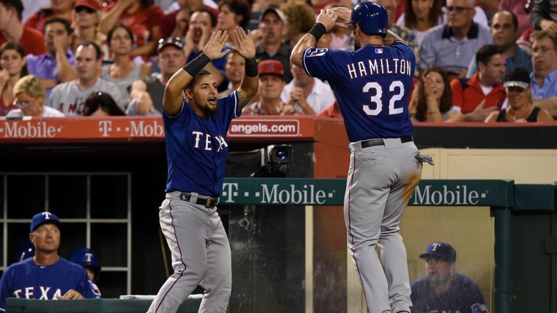 Jul 24, 2015; Anaheim, CA, USA; Texas Rangers left fielder Josh Hamilton (right) celebrates with second baseman Rougned Odor (12) after scoring during the fifth inning against the Los Angeles Angels at Angel Stadium of Anaheim. Mandatory Credit: Kelvin Kuo-USA TODAY Sports