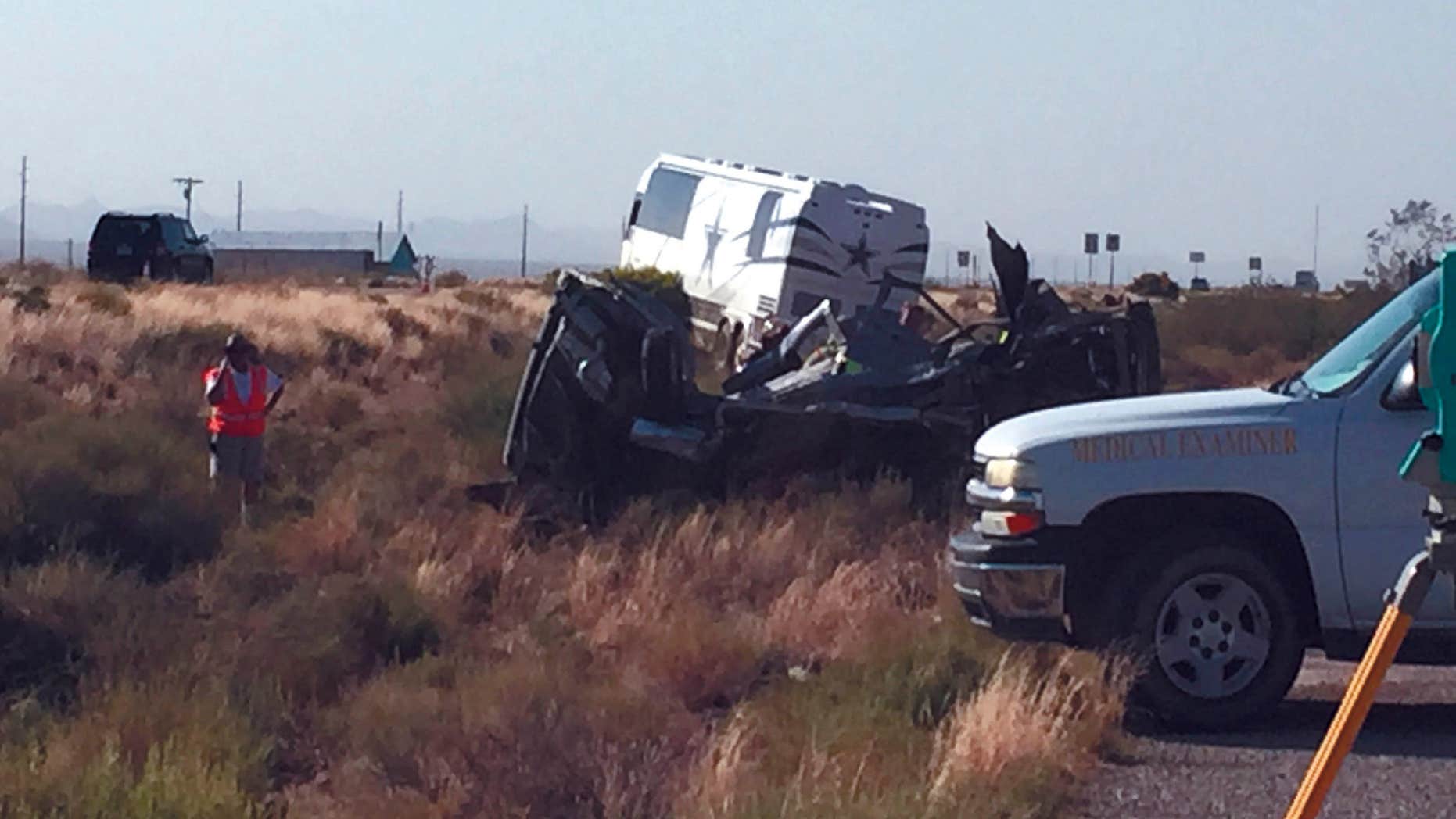 The scene of a bus crash is surveyed Sunday, July 24, 2016, on a highway in northwestern Arizona, about 30 miles north of Kingman.