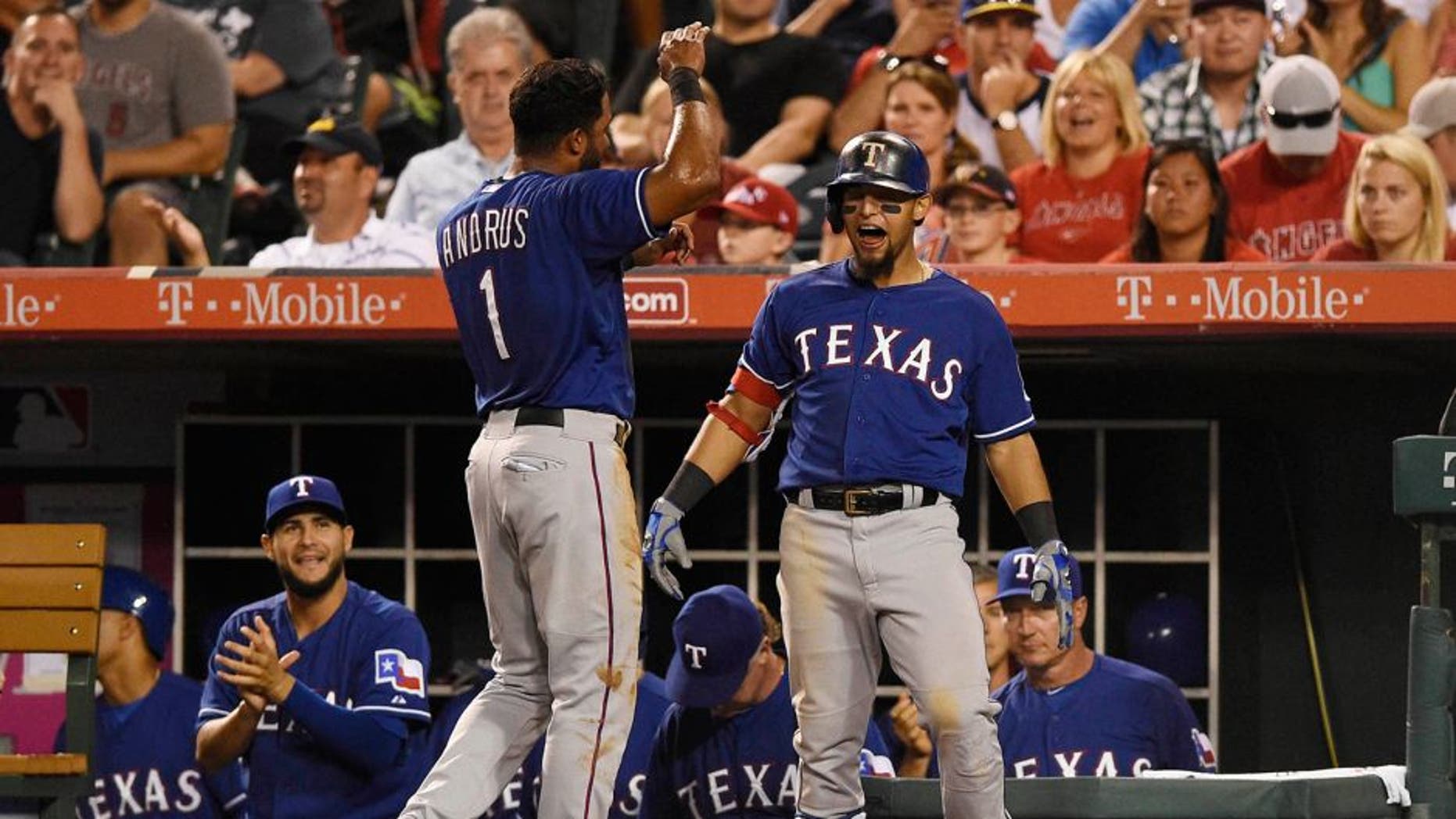 Jul 25, 2015; Anaheim, CA, USA; Texas Rangers second baseman Rougned Odor (12) and Texas Rangers shortstop Elvis Andrus (1) react after a run scored by Texas Rangers first baseman Mitch Moreland (not pictured) during the eighth inning against the Los Angeles Angels at Angel Stadium of Anaheim. Mandatory Credit: Kelvin Kuo-USA TODAY Sports