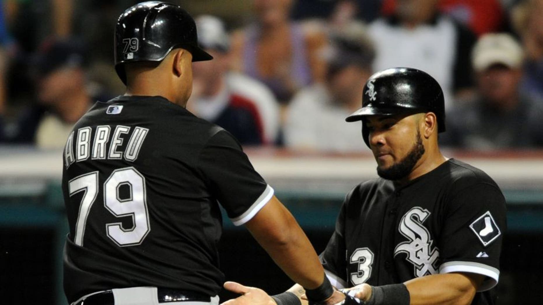 Jul 24, 2015; Cleveland, OH, USA; Chicago White Sox first baseman Jose Abreu (79) and Chicago White Sox left fielder Melky Cabrera (53) celebrate after scoring during the eighth inning against the Cleveland Indians at Progressive Field. The White Sox won 6-0.
